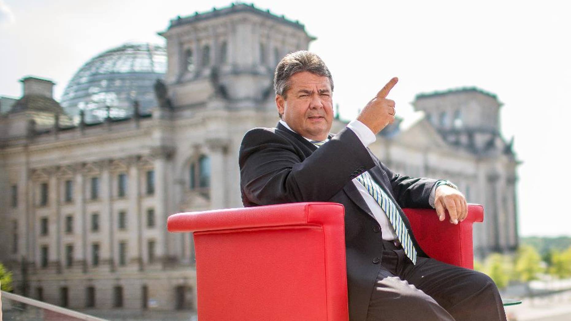 German vice chancellor and Minister for Economy, Sigmar Gabriel attends an interview by German TV channel ARD in Berlin, Sunday July 27, 2014. In background the parliament building 'Reichstag' . Germany’s vice chancellor says Europe should take aim at rich businesspeople who support Russia’s government as it increases pressure on Moscow over its actions in Ukraine. Sigmar Gabriel, who is also Germany’s economy minister, told ARD television Sunday that measures should target “those on whose shoulders the Russian government stands: the oligarchs, the billionaires.” (AP Photo/dpa/Hannibal Hanschke)