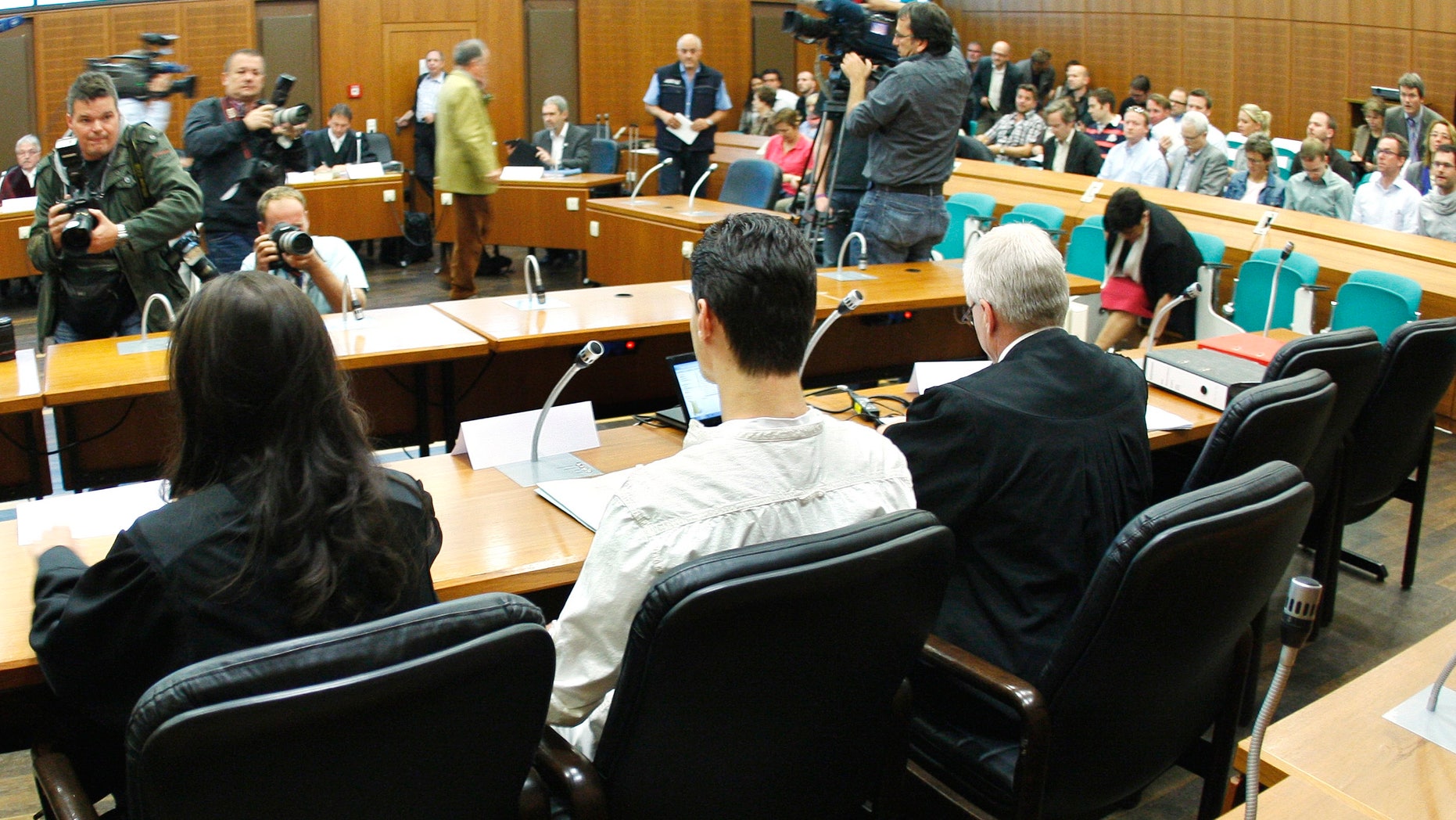 Aug. 31, 2011: 21-year old Arid Uka, center, photographed from behind, waits for the beginning of his trial at a court in Frankfurt, Germany.