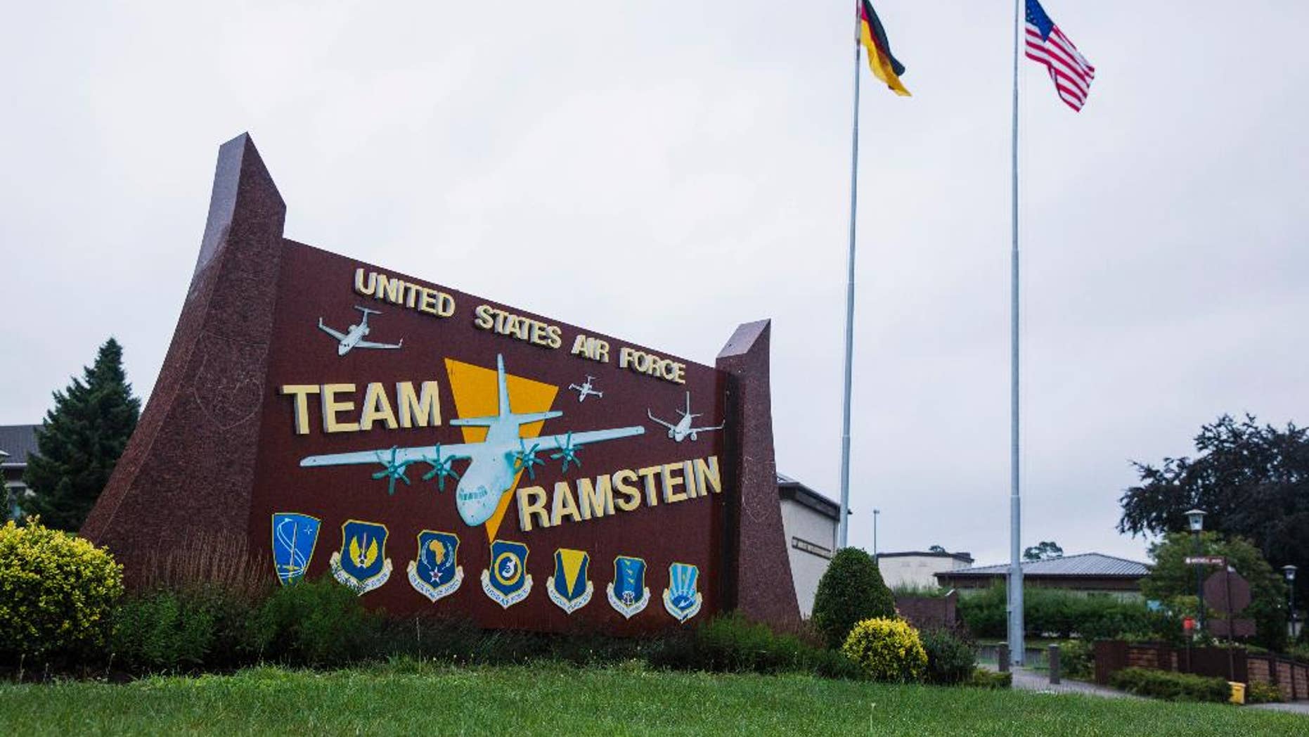 FILE - In this July 30, 2014 file photo the flags of the United States and Germany fly behind a sign at Ramstein Air Base, Germany. A Yemeni man is suing the German government for allegedly letting the United States use the air base in Germany for lethal drone strikes. Faisal bin Ali Jaber claims his brother-in-law Salim bin Ahmed Ali Jaber and nephew Waleed were killed in a U.S. drone strike in August 2012. (AP Photo/Lucas Jackson, Pool, File)