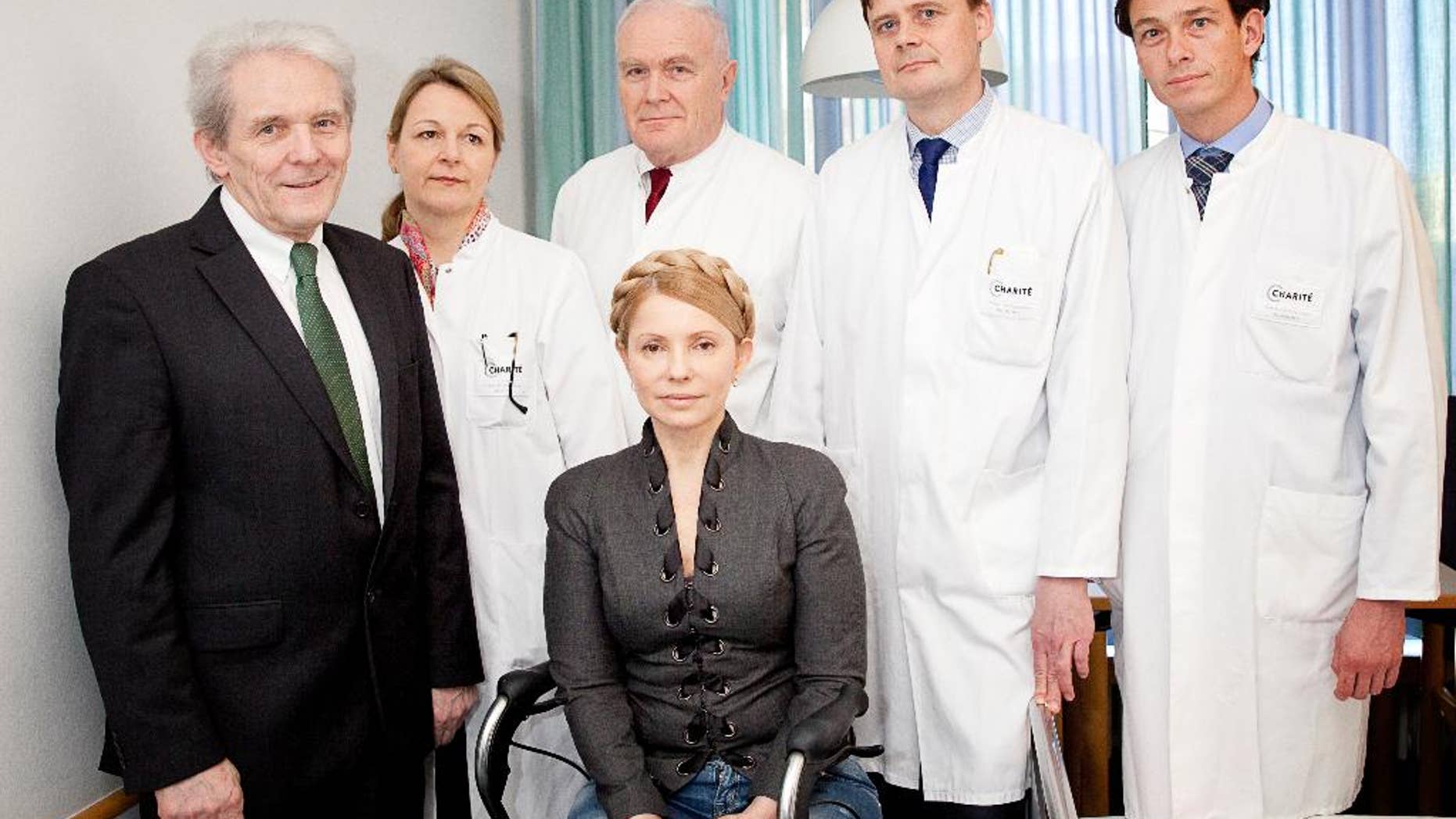 In this picture publicly provided by the Charite hospital in Berlin, former Ukrainian Prime Minister Yulia Tymoshenko , center, poses with her doctors Professor Karl Max Einhaeupl , left, CEO of the Charite Hospital and doctors from left : Dr. Anett Reisshauer , Professor Nobert Haas, Professor Matthias Endres, and Professor Peter Vajkoczy in the Charite Hospital in Berlin, Germany, on Saturday March 8, 2014. Ukraine's former prime minister, Yulia Tymoshenko, has started medical treatment at Berlin's Charite hospital after arriving late Friday, but doctors treating her say it's too soon to say how long this will take. (AP Photo/ho/Charite Universitaetsmedizin Berlin) MANDATORY CREDIT