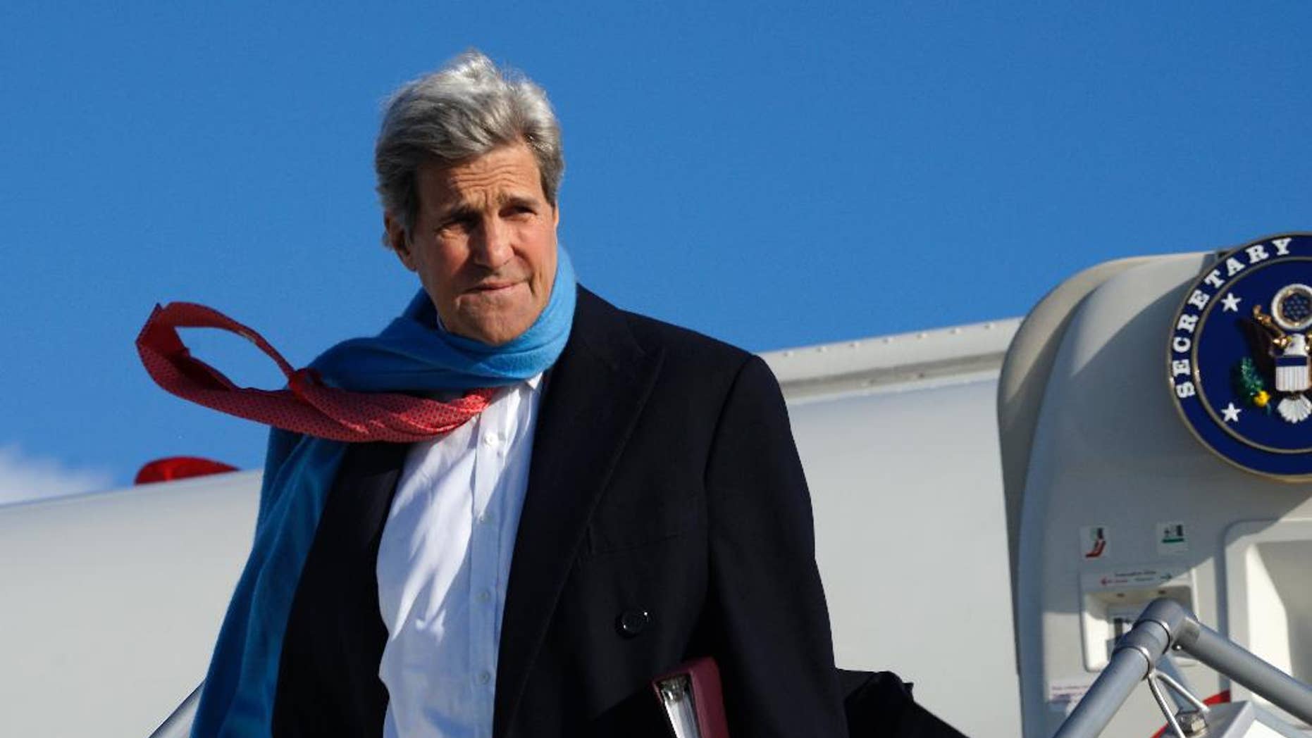 U.S. Secretary of State John Kerry reacts to the blustery weather on arrival in Munich, Germany on Saturday Jan. 10, 2015. Kerry was to meet Sultan Qaboos of Oman in Munich before traveling on to India. (AP Photo/Rick Wilking. Pool)