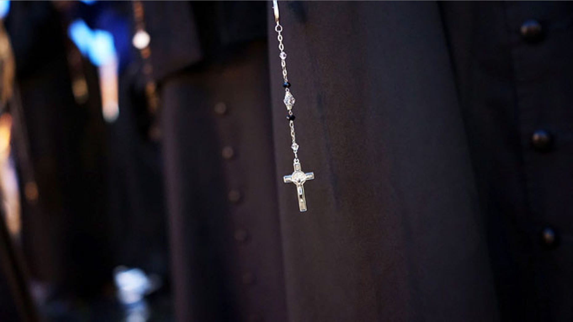 VATICAN CITY, VATICAN - MARCH 12: A priest holds a crucifix while waiting for a sign of smoke in St. Peter's Square on March 12, 2013 in Vatican City, Vatican. Pope Benedict XVI's successor is being chosen by the College of Cardinals in Conclave in the Sistine Chapel. The 115 cardinal-electors, meeting in strict secrecy, will need to reach a two-thirds-plus-one vote majority to elect the 266th Pontiff. (Photo by Spencer Platt/Getty Images)