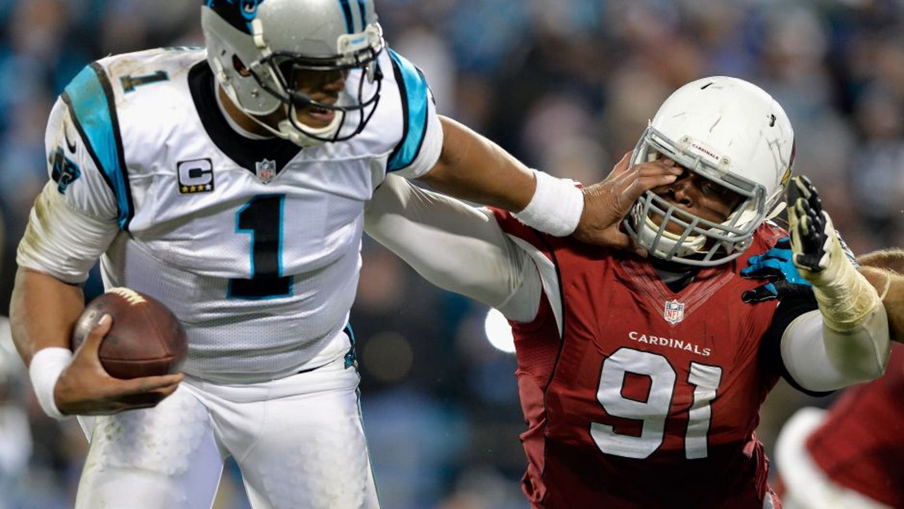 CHARLOTTE, NC - JANUARY 24: Cam Newton #1 of the Carolina Panthers stiff arms Ed Stinson #91 of the Arizona Cardinals in the second half during the NFC Championship Game at Bank of America Stadium on January 24, 2016 in Charlotte, North Carolina. (Photo by Grant Halverson/Getty Images)