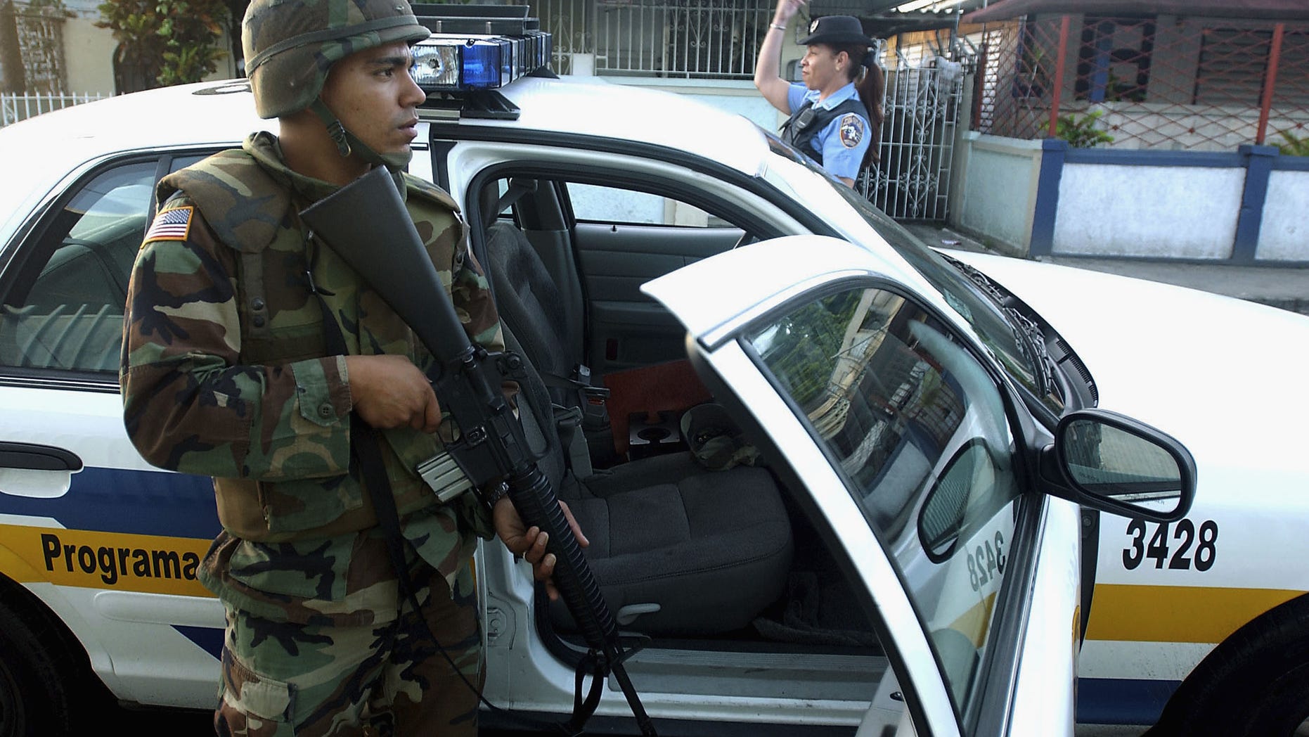 SAN JUAN, PUERTO RICO - JULY 23: U.S. Army Specialist Michael Montijo joins Puerto Rico Police Department officers on an early morning patrol July 23, 2004 in San Juan, Puerto Rico. Puerto Rico Governor Sila Maria Calderon activated 500 National Guardsmen to try to bring stability after a crime wave swept the island. (Photo by Jose Jimenez/Getty Images)