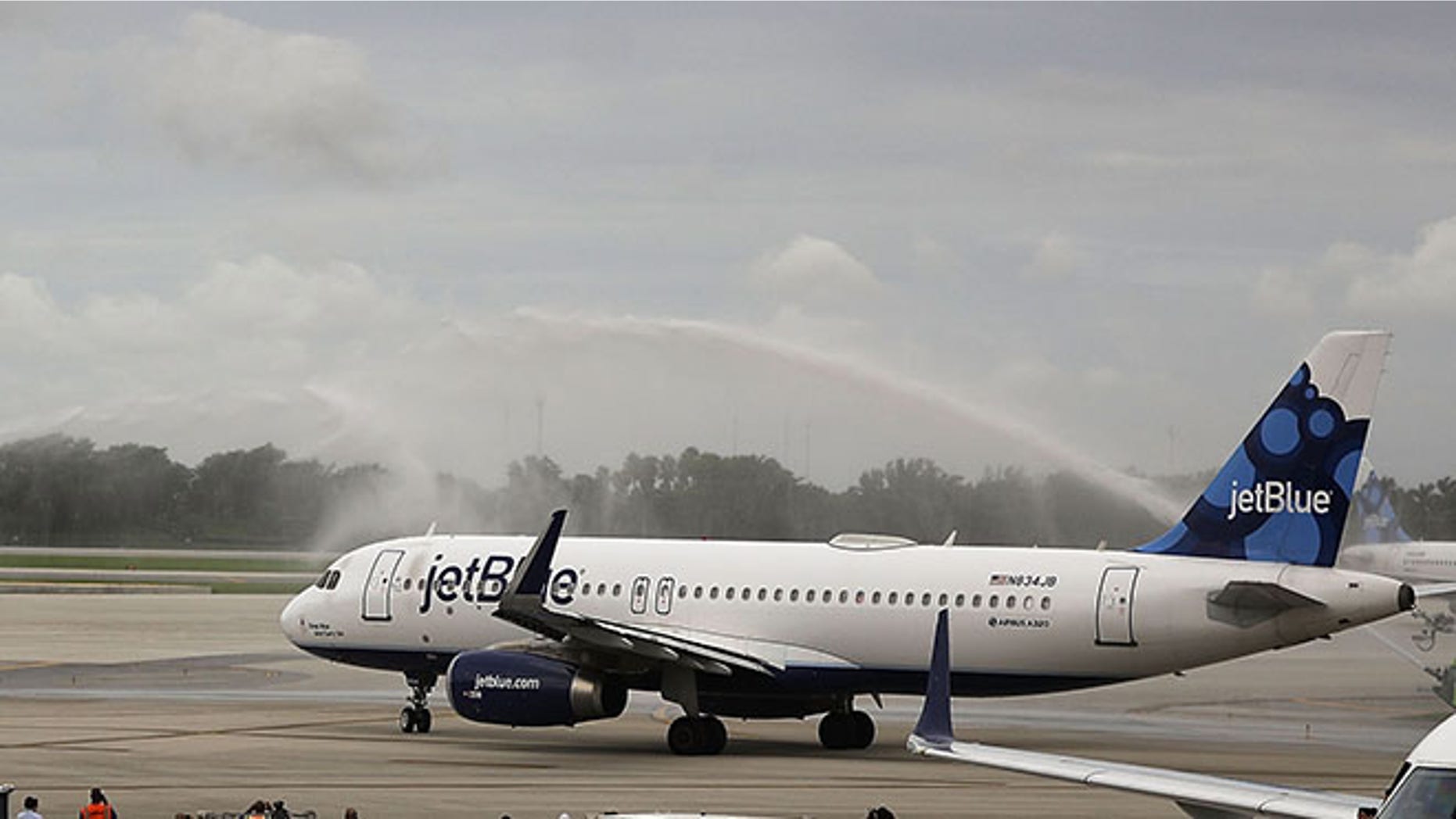 FORT LAUDERDALE, FL - AUGUST 31: Workers watch as JetBlue Flight 387 is given a water cannon salute as it prepares for take off to become the first scheduled commercial flight to Cuba since 1961 on August 31, 2016 in Fort Lauderdale, Florida. JetBlue which hopes to have as many as 110 daily flights is the first U.S. airline to resume regularly scheduled airline service under new rules allowing Americans greater access to Cuba. (Photo by Joe Raedle/Getty Images)