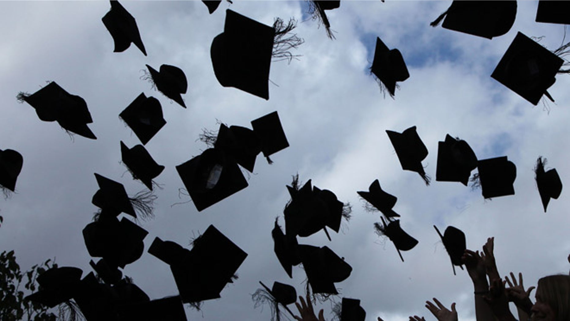 BIRMINGHAM, ENGLAND - JULY 14: Students throw their mortarboards in the air during their graduation photograph at the University of Birmingham degree congregations on July 14, 2009 in Birmingham, England. Over 5000 graduates will be donning their robes this week to collect their degrees from The University of Birmingham. A recent survey suggested that there are 48 graduates competing for every job. (Photo by Christopher Furlong/Getty Images)
