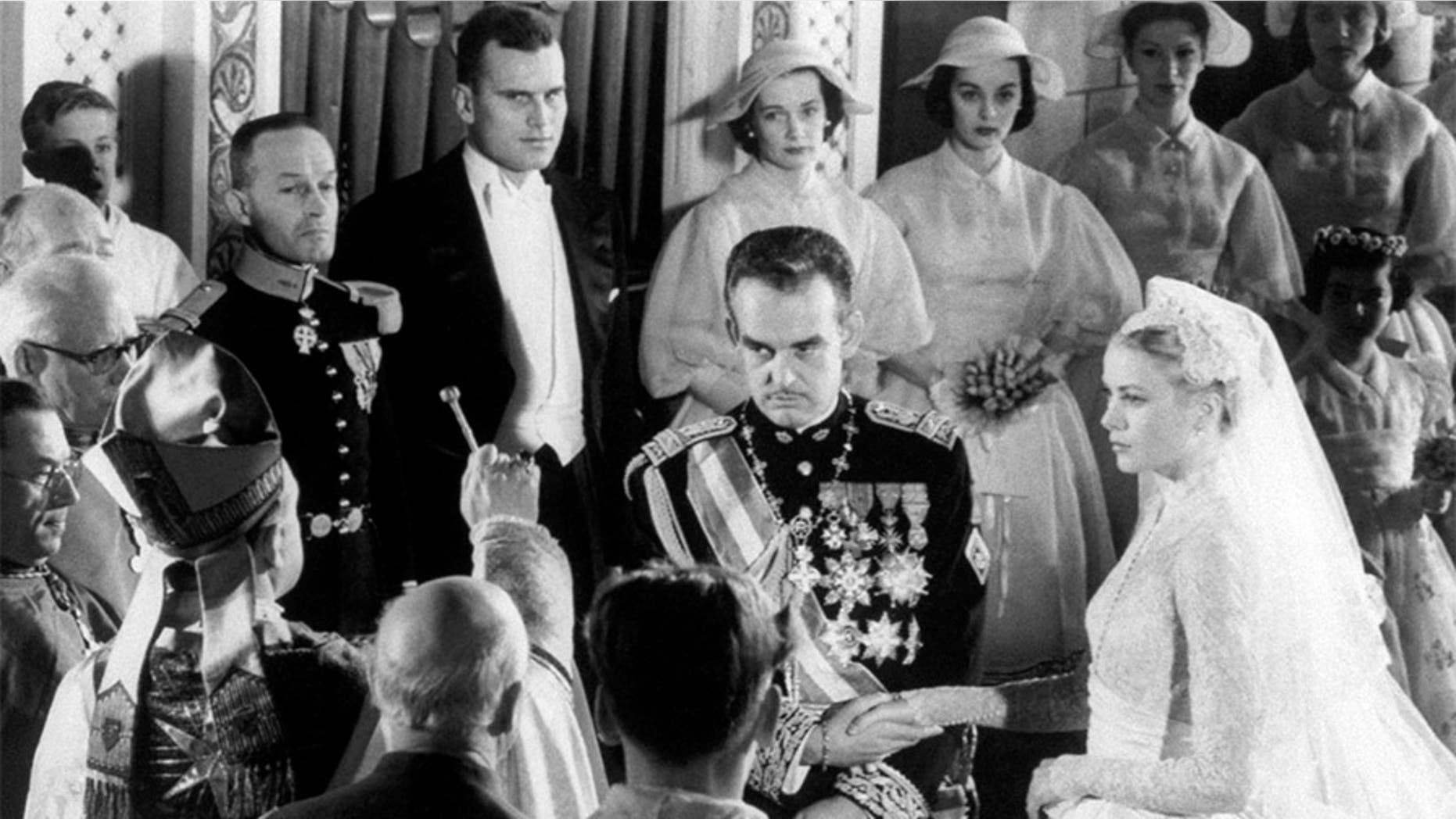 Prince Rainier of Monaco and actress Grace Kelly join hands as Bishop of Monte Carlo Mgr. Gilles Barthe gives them nuptial benediction, during their wedding ceremony at Saint Nicholas Cathedral.