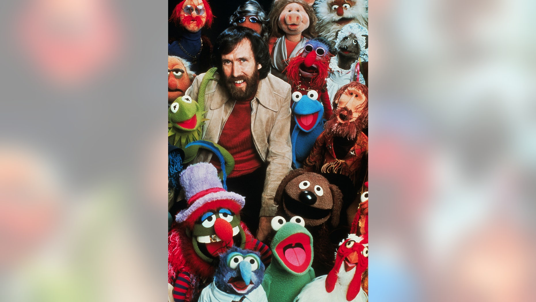 Jim Henson, American puppeteer and creator of "The Muppets," poses with his creations.