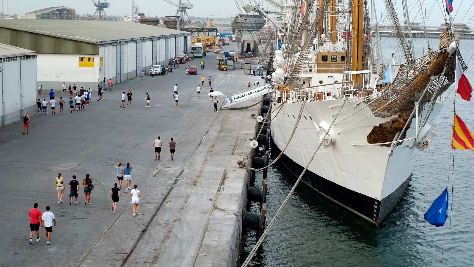 The crew of the flagship of Argentin's navy, the A.R.A. Libertad, run along the dock at the port of Tema, outside Accra, Ghana, Thursday, Oct 11, 2012, where the Libertad is being held.
