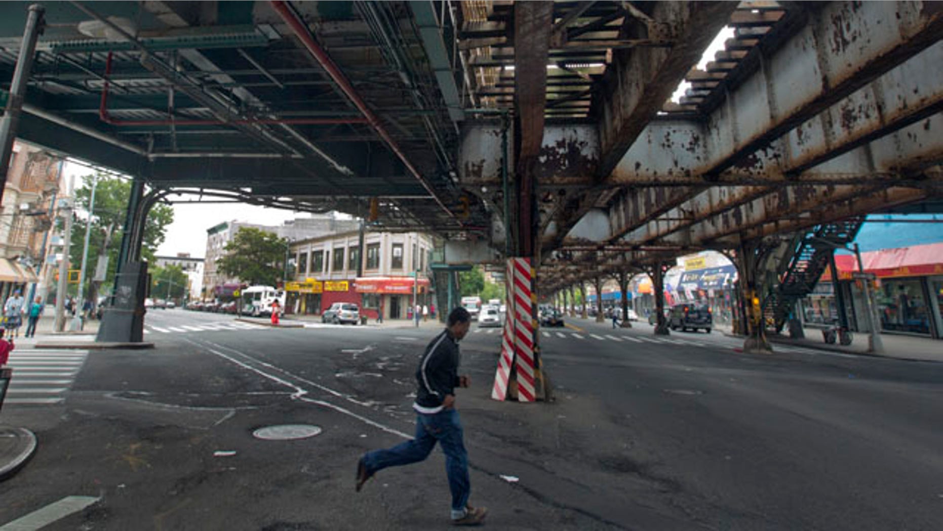May 22, 2013: A young man runs under an elevated section of subway tracks in The Bronx borough of New York.