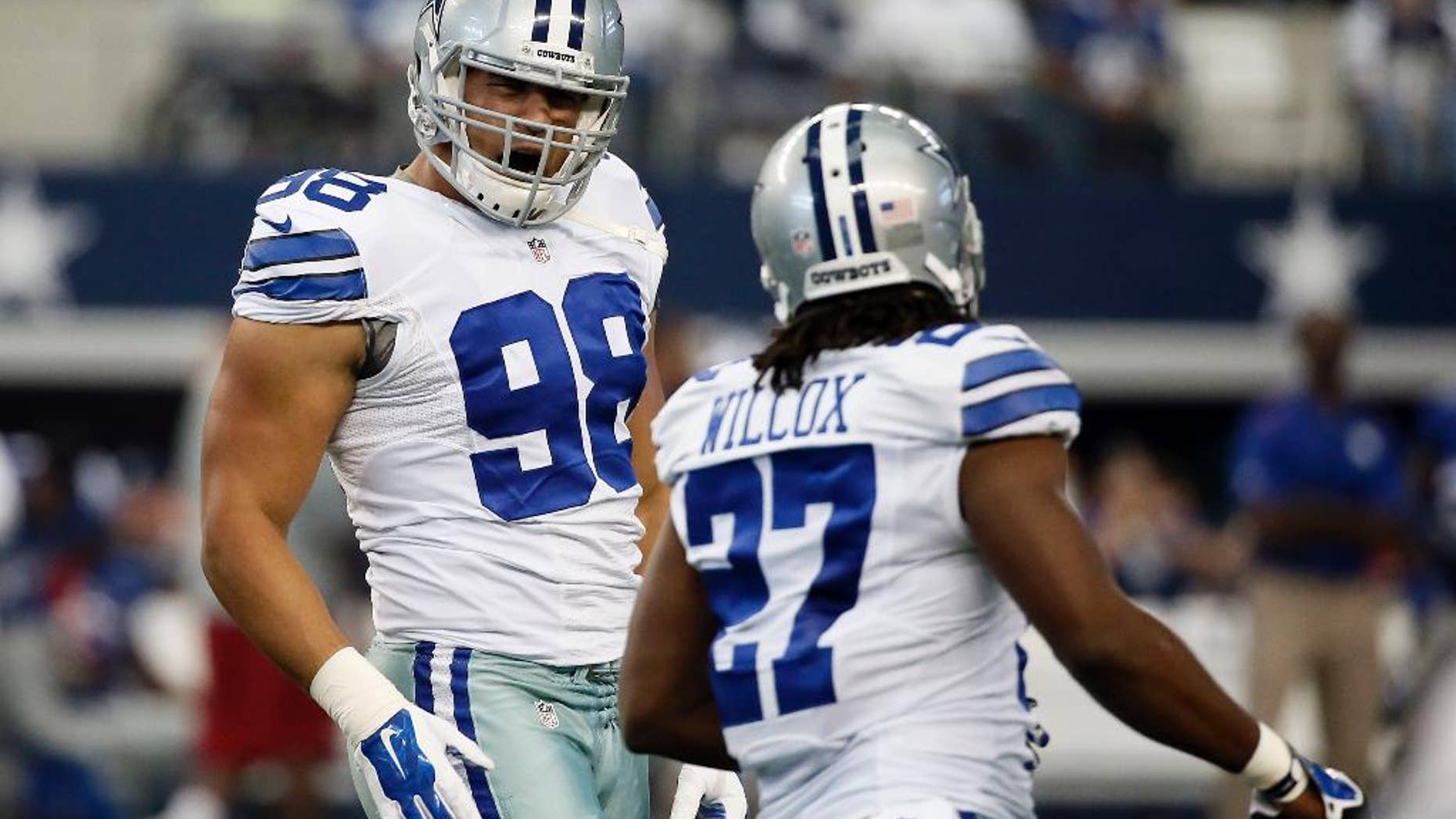 Dallas Cowboys defensive end Tyrone Crawford (98) and strong safety J.J. Wilcox (27) celebrate a defensive stop against the New York Giants during the first half of an NFL football game, Sunday, Oct. 19, 2014, in Arlington, Texas. (AP Photo/Brandon Wade)