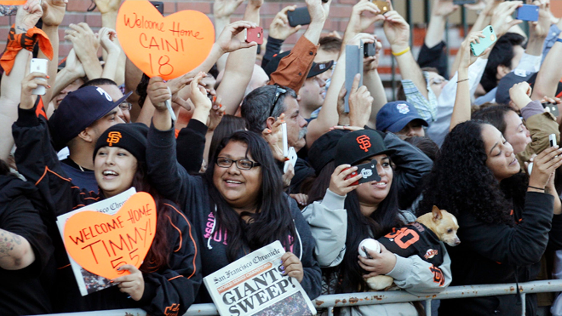 Oct. 29, 2012: San Francisco Giants fans cheer as the team buses arrive outside of AT&T Park in San Francisco.