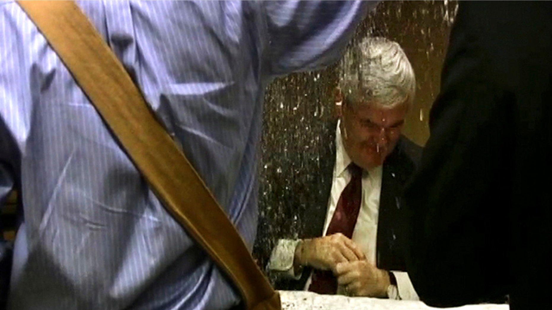May 17: In this image taken from video, a protester dumps glitter on a table where GOP presidential hopeful Newt Gingrich and his wife, Callista, were signing books at a hotel in Minneapolis.