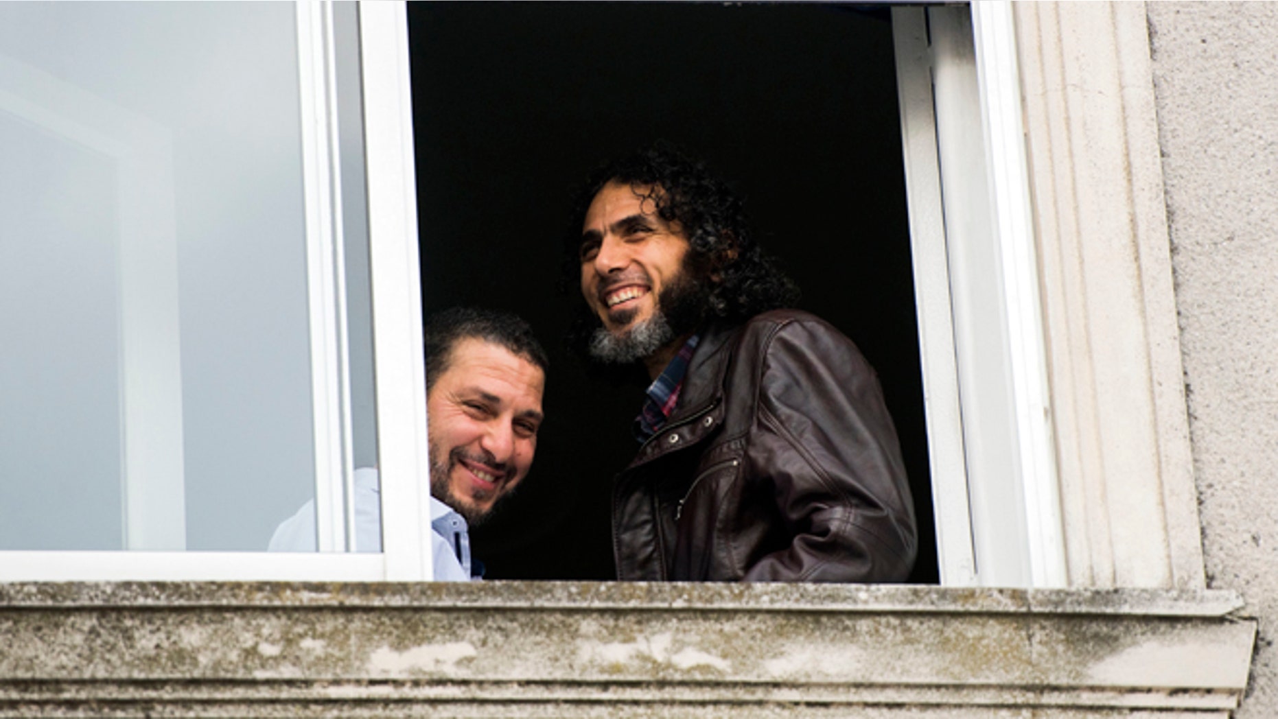FILE - In this June 5, 2015 file photo, Abu Wa'el Dhiab, from Syria, right, and Adel bin Muhammad El Ouerghi, of Tunisia, both freed Guantanamo Bay detainees, stand next to the window of their shared home in Montevideo, Uruguay. The new U.S. ambassador in Uruguay expressed concern on Monday, July 11, 2016, about the lack of information on the whereabouts of Abu Wa'el Dhiab. (AP Photo/Matilde Campodonico, File)