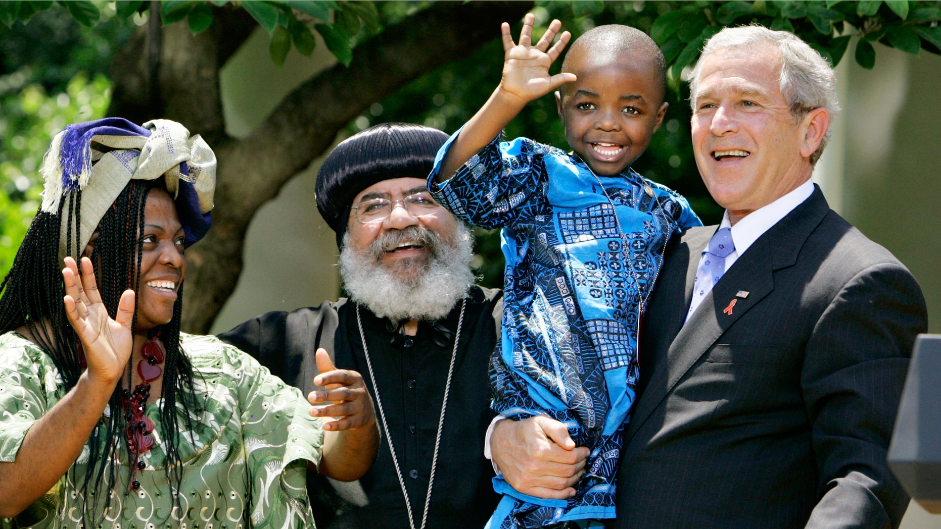 In this May 30, 2007, file photo President Bush, right, hoists 4-year-old Baron Mosima Loyiso Tantoh, son of Manyongo Mosima "Kuene" Tantoh of South Africa, left, who is HIV-positive, after speaking about his efforts to fight HIV/AIDS worldwide, in the Rose Garden of the White House in Washington. (AP Photo/J. Scott Applewhite, File)