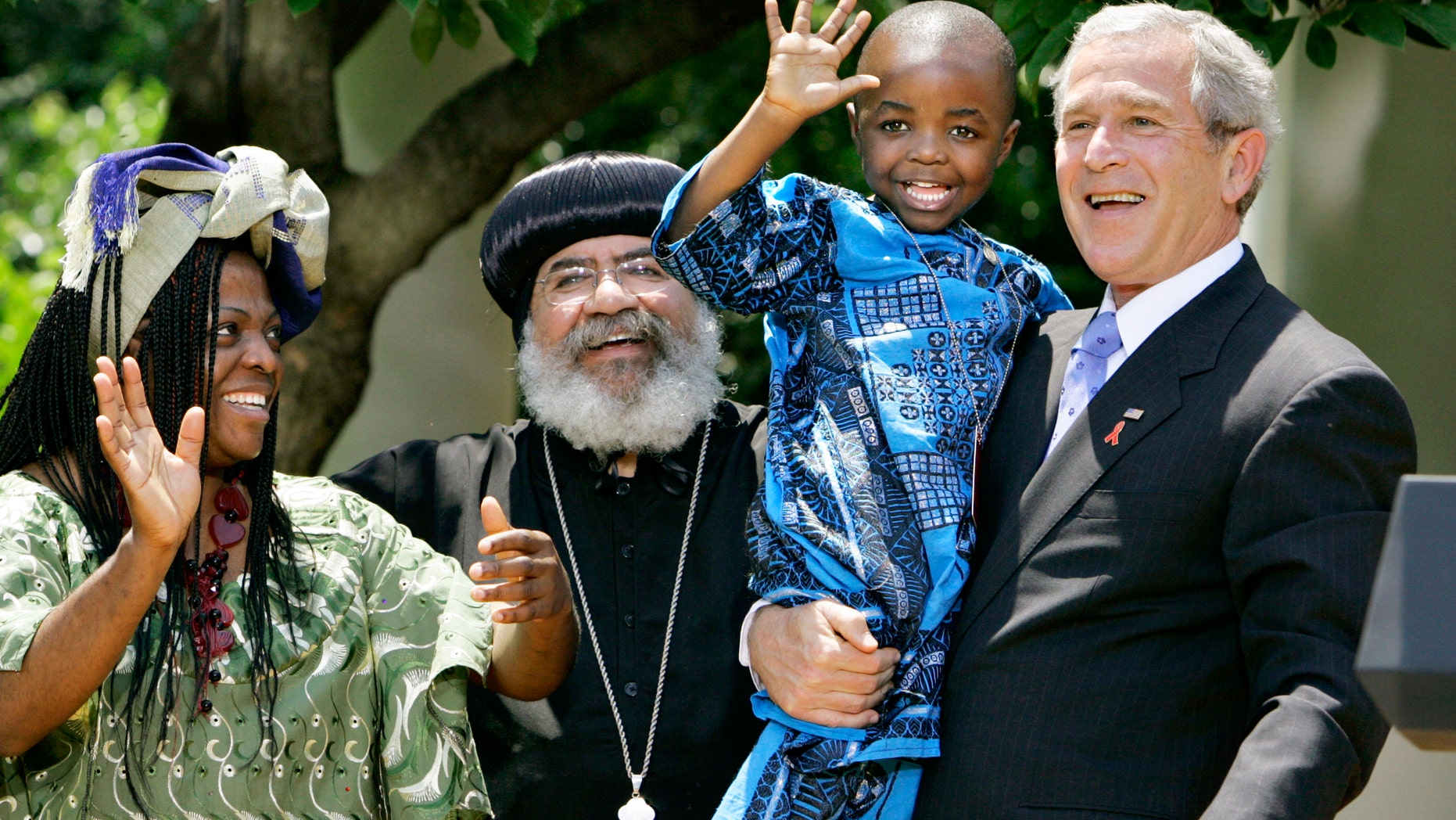 In this May 30, 2007, file photo President Bush, right, hoists 4-year-old Baron Mosima Loyiso Tantoh, son of Manyongo Mosima "Kuene" Tantoh of South Africa, left, who is HIV-positive, after speaking about his efforts to fight HIV/AIDS worldwide, in the Rose Garden of the White House in Washington.