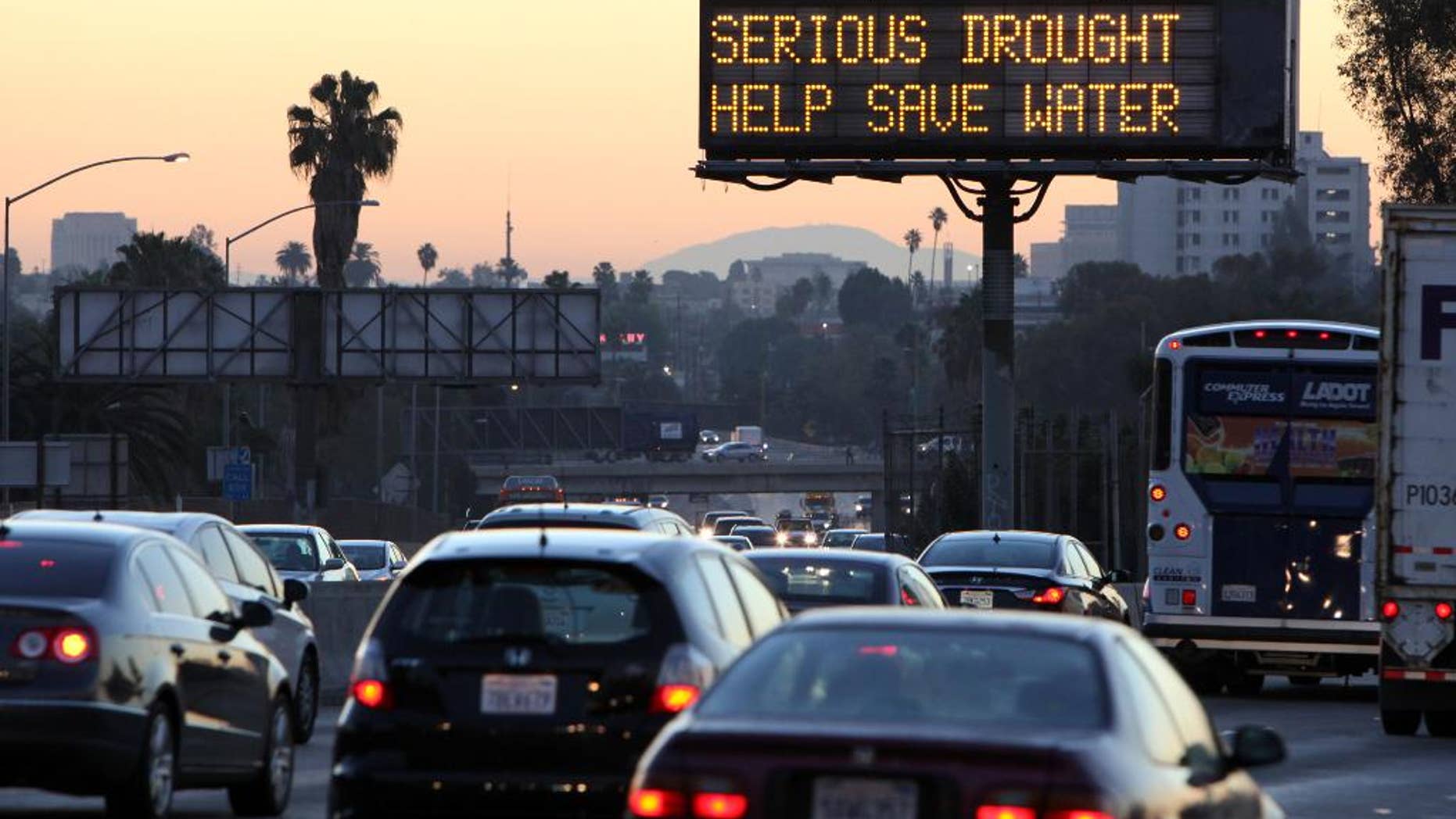 FILE - In this Friday, Feb. 14, 2014, file photo, morning traffic makes it's way toward downtown Los Angeles along the Hollywood Freeway past an electronic sign warning of severe drought. As of Wednesday, April 30, 2014, Pensacola, Florida, got more rain in one stormy day than drought-struck Los Angeles has had in more than two years. (AP Photo/Richard Vogel, File)