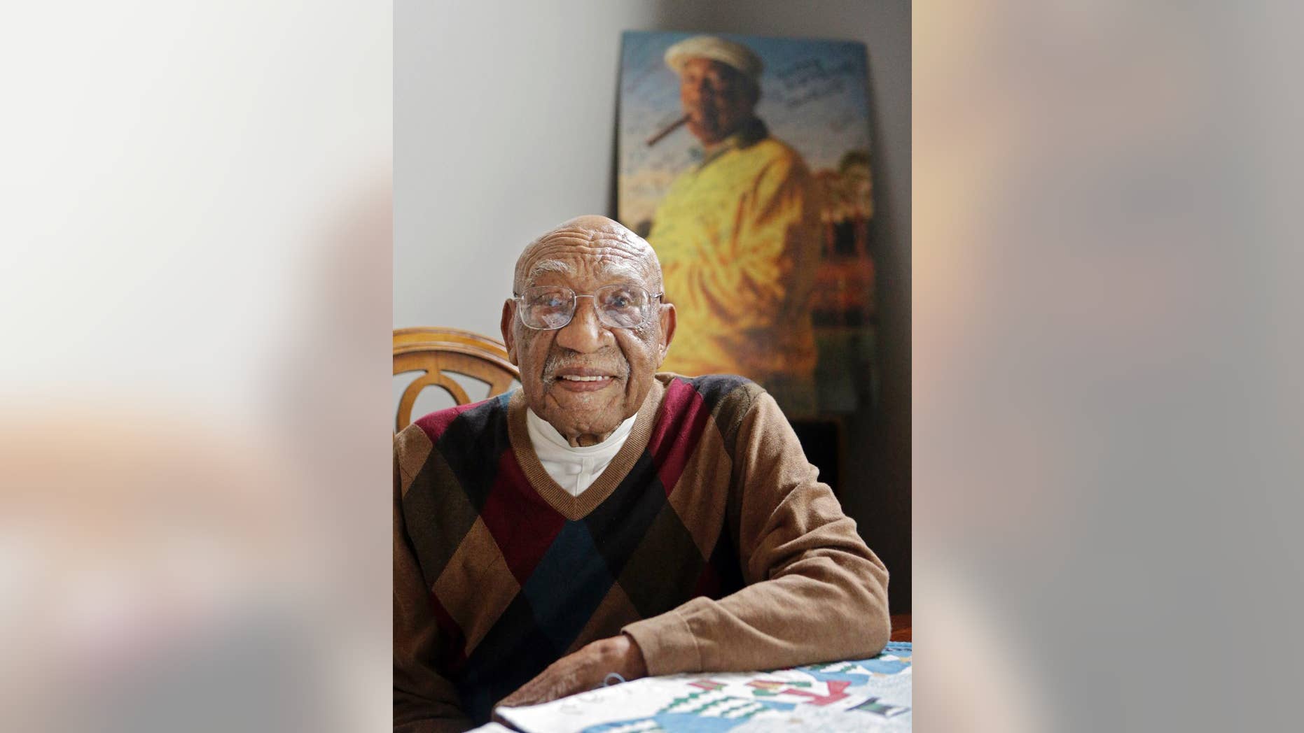 FILE-In this Nov. 13, 2014 file photo former PGA golfer Charlie Sifford sits in the dining room in his home in Brecksville, Ohio. Authorities say the son and ex-daughter-in-law of the late black golfing pioneer Sifford have been indicted on charges related to the theft of more than $1 million from him. Craig and Sandra Sifford were charged Tuesday, July 28, 2015 with theft, money laundering and unauthorized use of property. Both are 48. The Cuyahoga County prosecutor's office says they spent Sifford's money on travel, dining, clothes, jewelry and landscaping. (AP Photo/Mark Duncan, File)