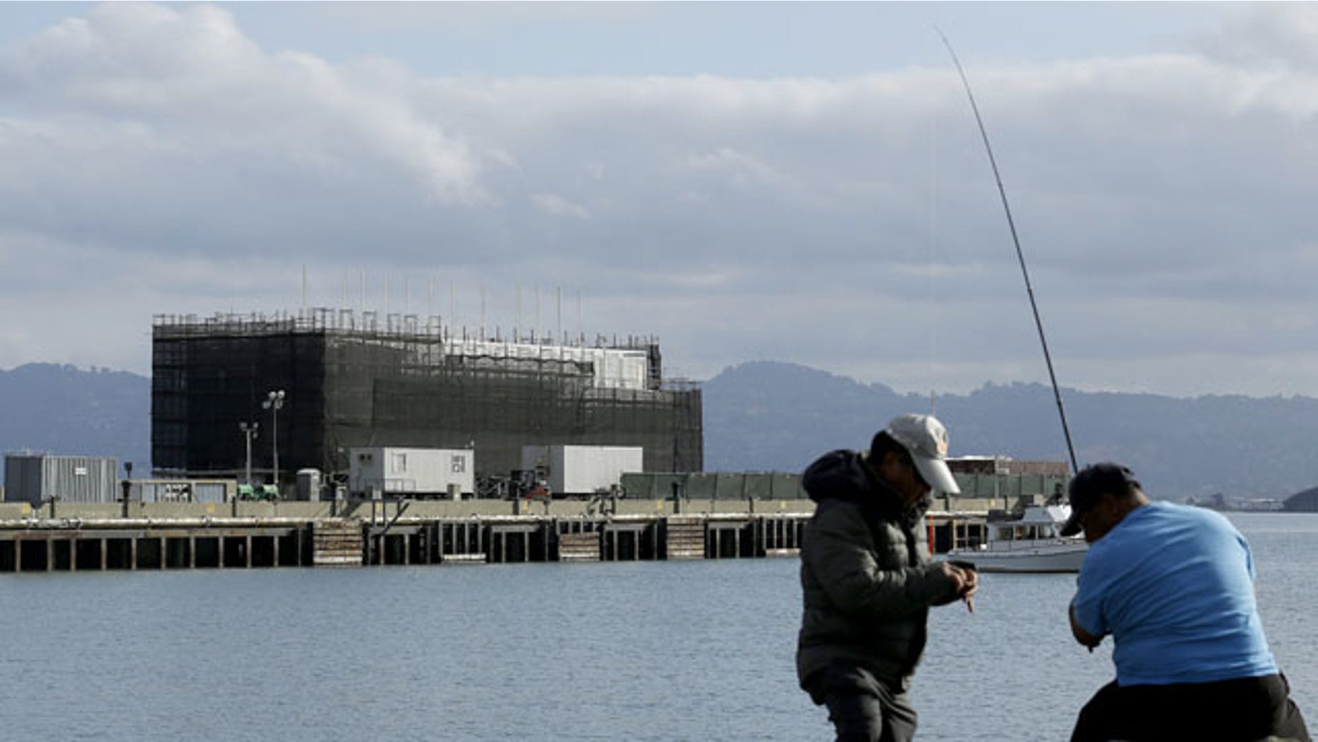 Oct. 29, 2013: Two men fish in the water in front of a Google barge on Treasure Island in San Francisco.