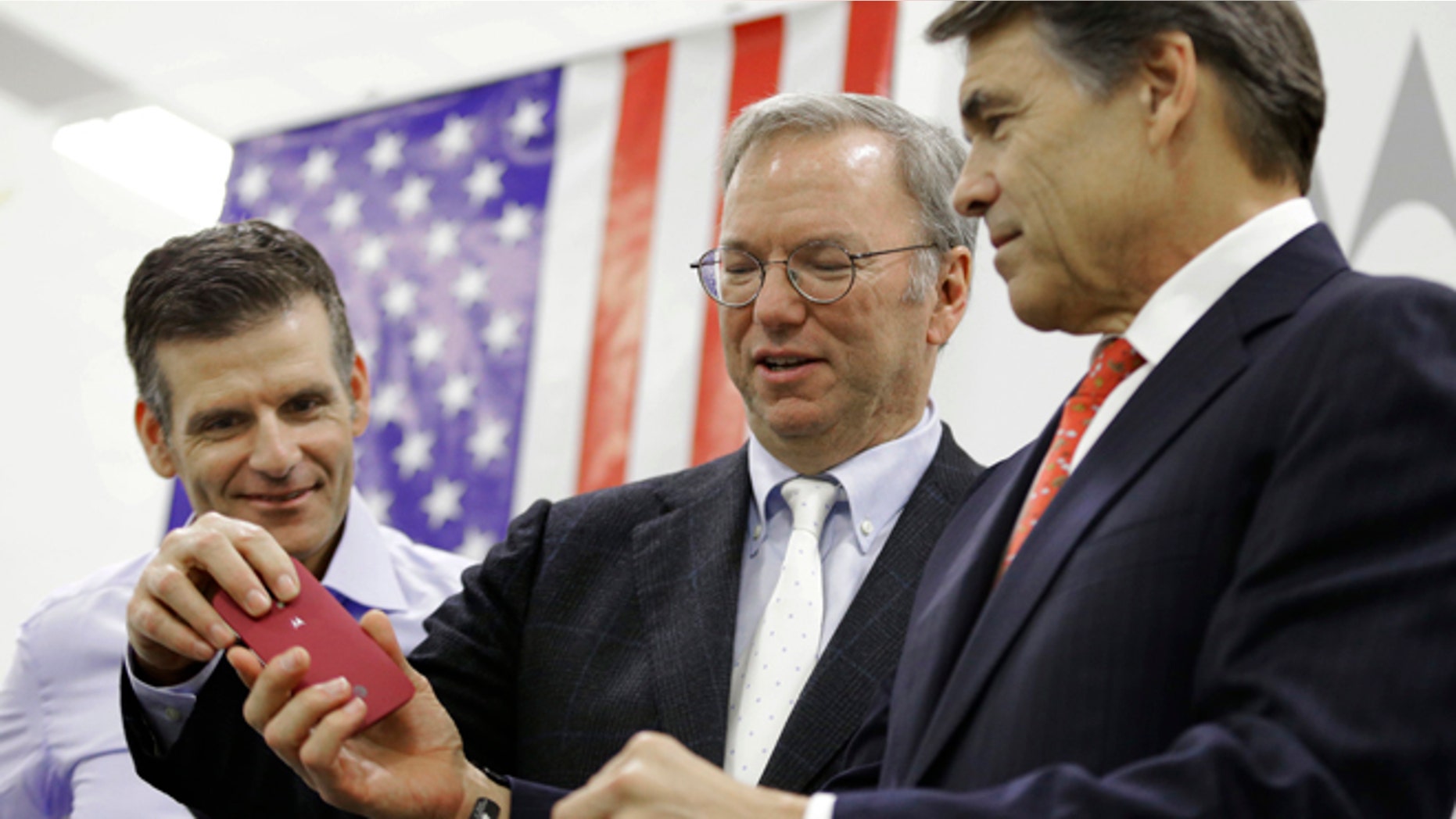 Sept. 10, 2013: Google Executive Chairman Eric Schmidt, center, helps Texas Gov. Rick Perry with his smart phone as Dennis Woodside, Motorola CEO, looks on during the opening ceremony for a Motorola smartphone factory in Texas.