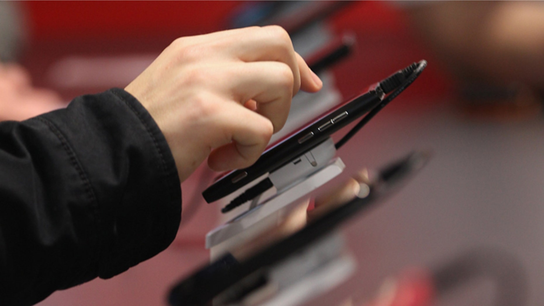 HANOVER, GERMANY - MARCH 06: A visitor tries out Microsoft-driven smartphones on the first day of the CeBIT 2012 technology trade fair on March 6, 2012 in Hanover, Germany. CeBIT 2012, the world's largest information technology trade fair, will run from March 6-10, and advances in cloud computing and security are major features this year. (Photo by Sean Gallup/Getty Images)