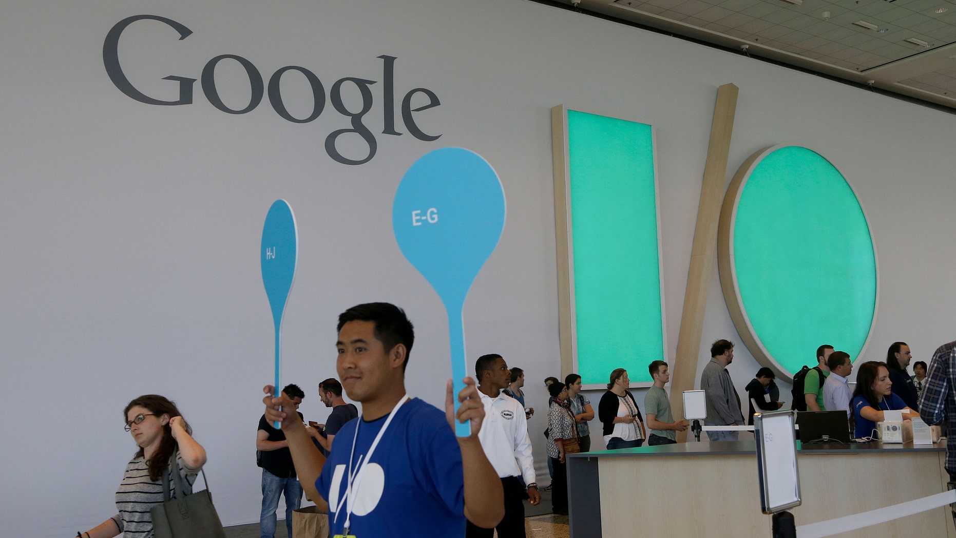 A Google employee helps direct people as they register for Google I/O 2014 in San Francisco.