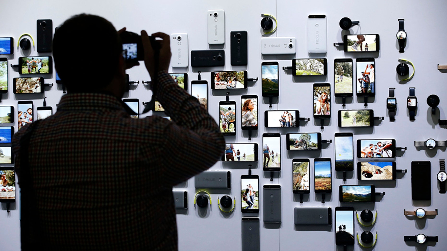 A reporter takes a picture of new Google devices on display during a Google event on Tuesday, Sept. 29, 2015, in San Francisco.