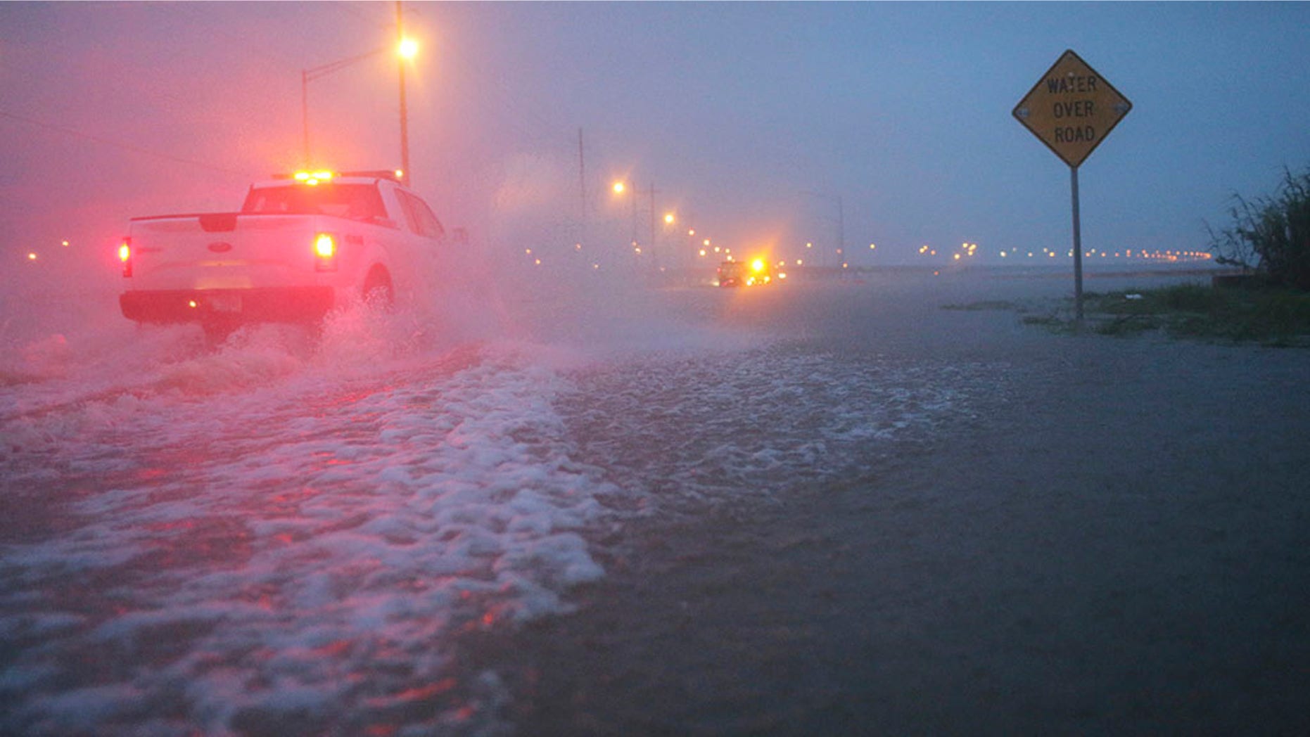 Trucks with the Alabama Department of Transportation work to block off a flooded part of US Highway 98 while fighting rain from Tropical Storm Gordon on Wednesday, Sept. 5, 2018, in Spanish Fort, Ala. Tropical Storm Gordon never became a hurricane but it was deadly all the same, as it made landfall late Tuesday just west of the Alabama-Mississippi border. (AP Photo/Dan Anderson)
