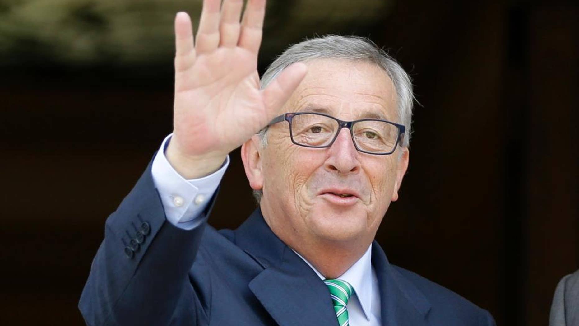 Jean-Claude Juncker, president-elect of the European Commission, left, waves to the media at the Maximos Mansion in Athens, Monday, Aug. 4, 2014. Juncker is visit Athens in his first trip since his election by the new European Parliament last month. He meets Greek Prime Minister Antonis Samaras, a fellow conservative, to express support for the country's ongoing effort to make its public finances sustainable. (AP Photo/Thanassis Stavrakis)