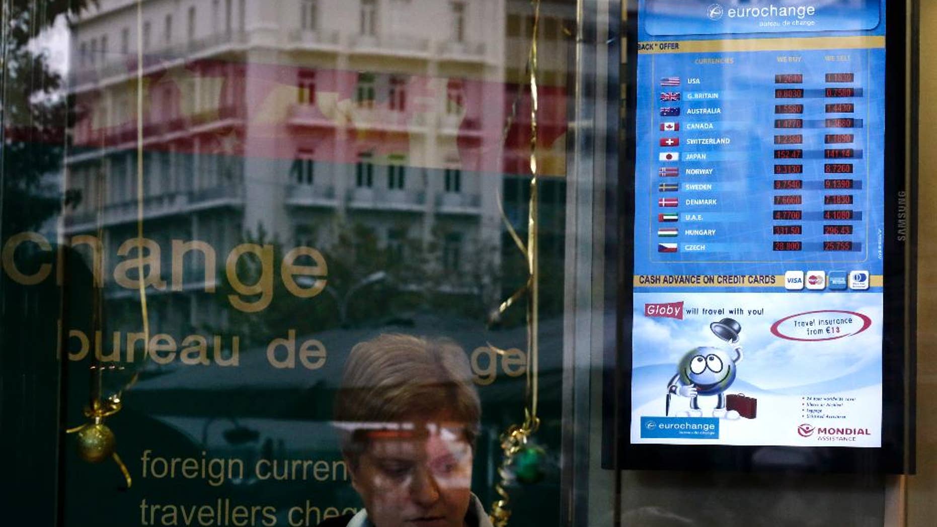 The exchange rate of the US Dollar and the Euro, at top, is displayed in the window of a currency exchange office in Athens, on Monday, Jan. 5, 2015. The euro sank to a nine-year low Monday as new doubts surfaced about Greece's commitment to the common currency bloc. European stocks mostly rose while Asian markets were mixed. (AP Photo/Petros Giannakouris)