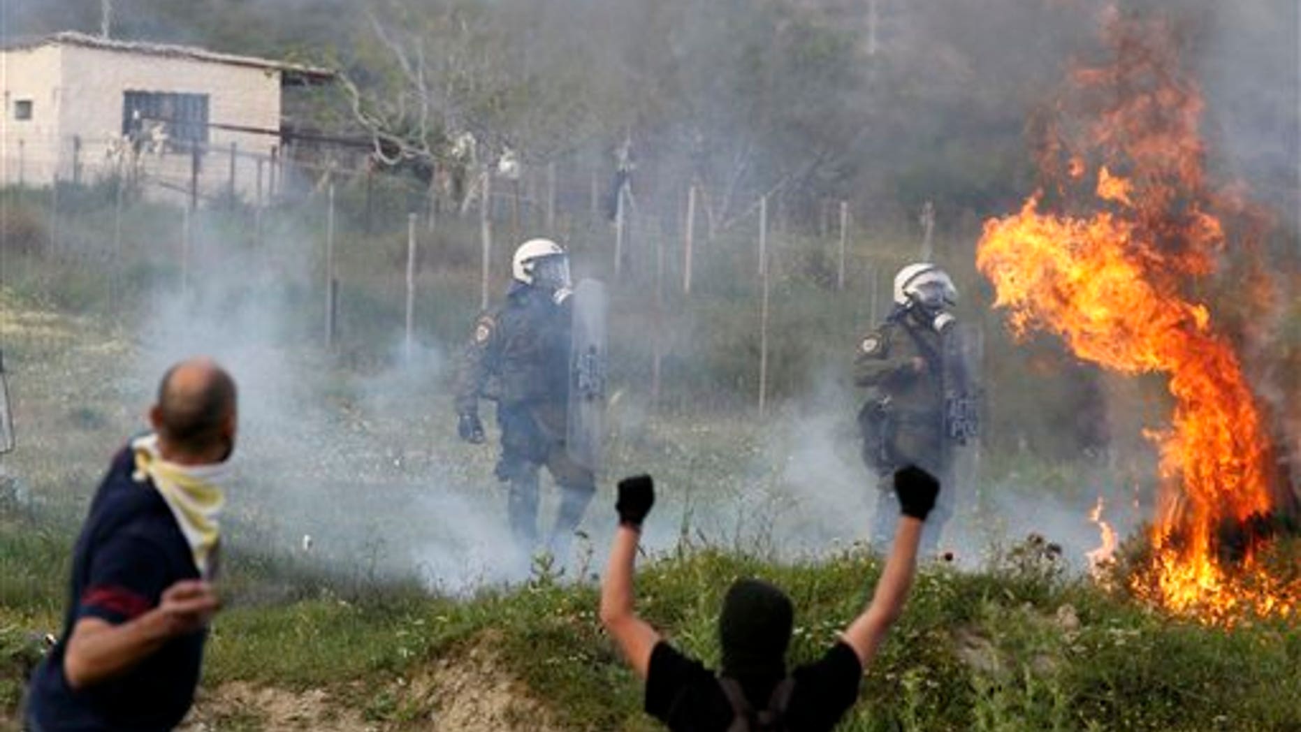April 14: Protesters attack with gas bombs and stone against riot police during clashes in the town of Keratea, about 31 miles southeast of Athens. Greek protesters have used excavators to cut a shoulder-high trench on a busy road near a proposed new landfill, cutting off traffic outside Athens. Youths clashed later Thursday at the site with riot police, who responded with tear gas. (AP)