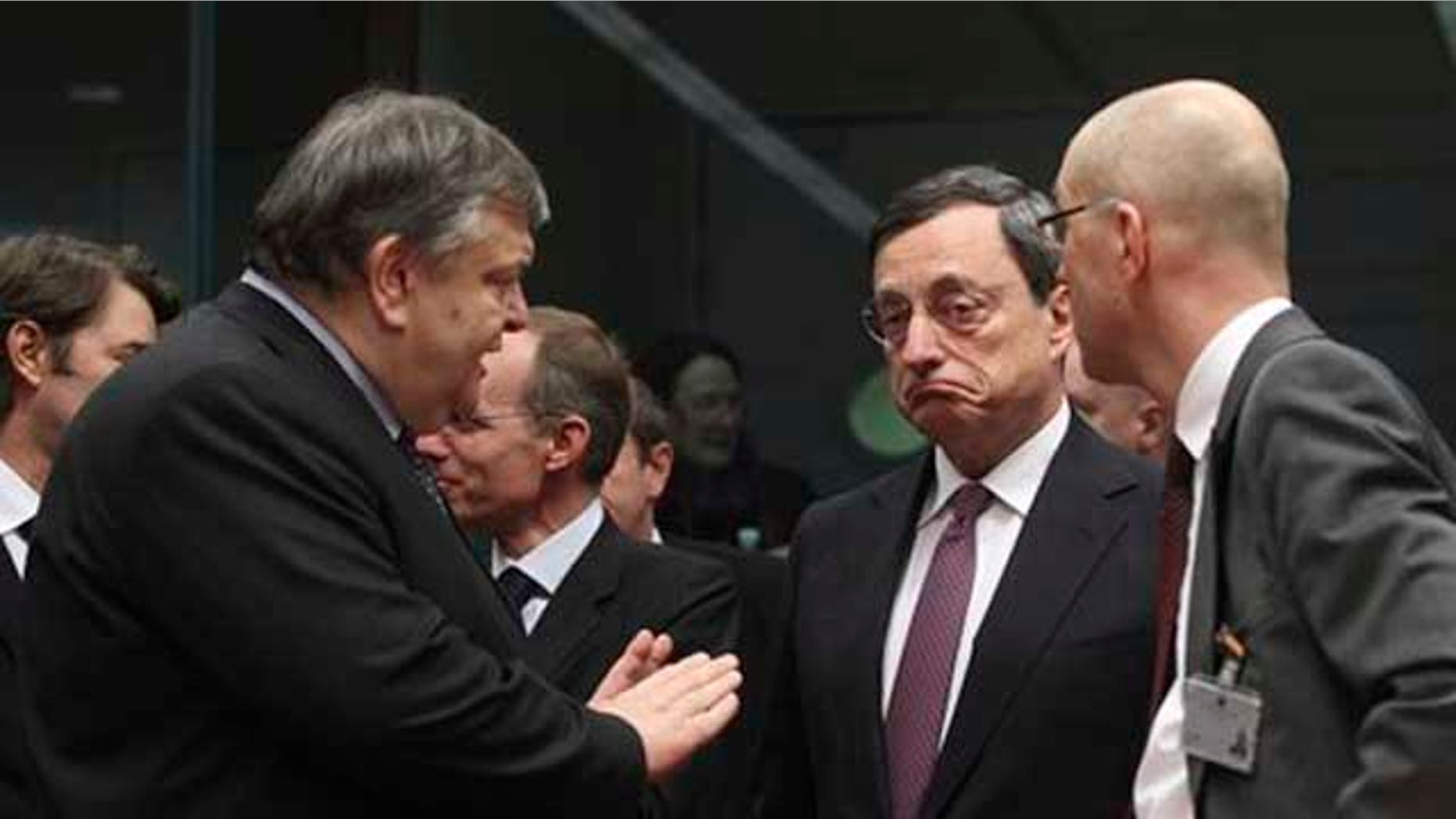 Feb. 20, 2012: Greek Finance Minister Evangelos Venizelos, left, gestures while speaking with European Central Bank President Mario Draghi, second right, during a round table meeting of eurozone finance ministers at the EU Council building in Brussels.