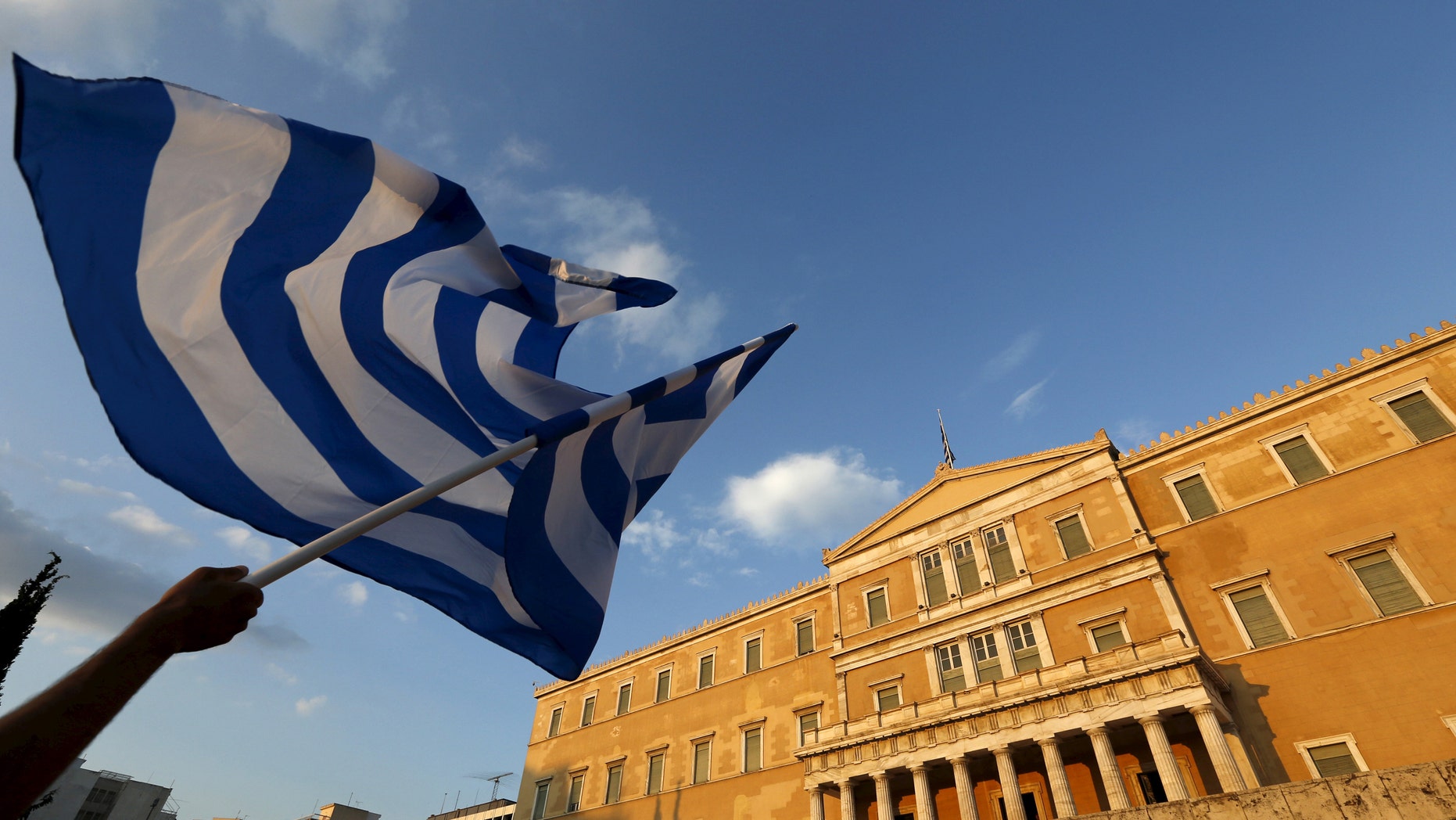 File photo - A protester waves a Greek flag during an anti-austerity rally in Athens, Greece, June 29, 2015.