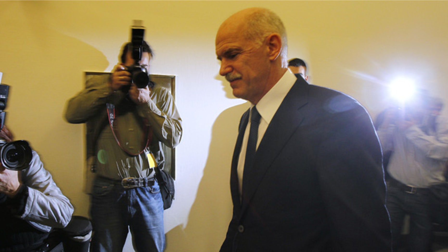 Greek Prime Minister George Papandreou returns to an emergency cabinet meeting after he took a short break at the Greek parliament in Athens, on Thursday, Nov. 3, 2011. A spokesman for Greece's government says it is prepared to discuss an opposition demand for the creation of a transitional government to approve the latest European bailout deal and secure the next installment of rescue loans for the country. (AP Photo/Thanassis Stavrakis)