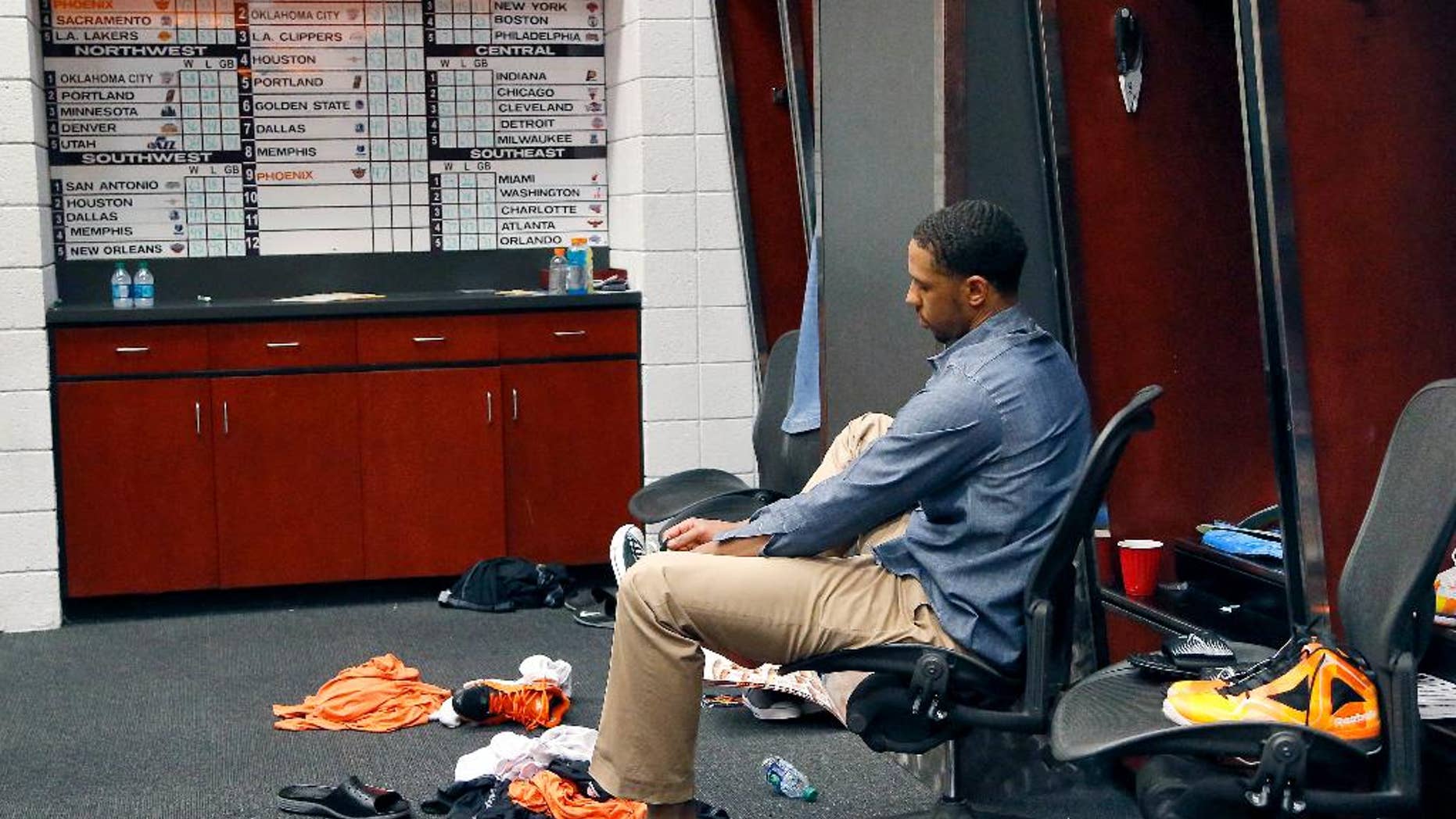 Phoenix Suns' Channing Frye laces up his shoe in the locker room after an NBA basketball game against the Memphis Grizzlies, Monday, April 14, 2014, in Phoenix. The Grizzlies won 97-91 eliminating the Suns from the playoffs. (AP Photo/Matt York)