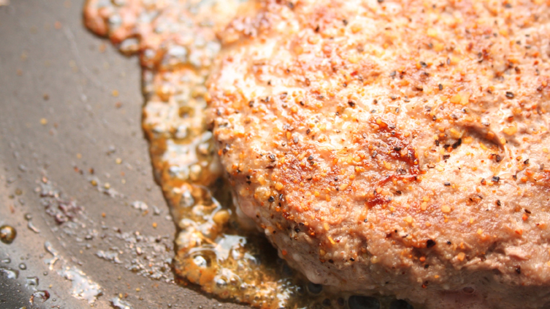 A turkey burger in a frying pan.
