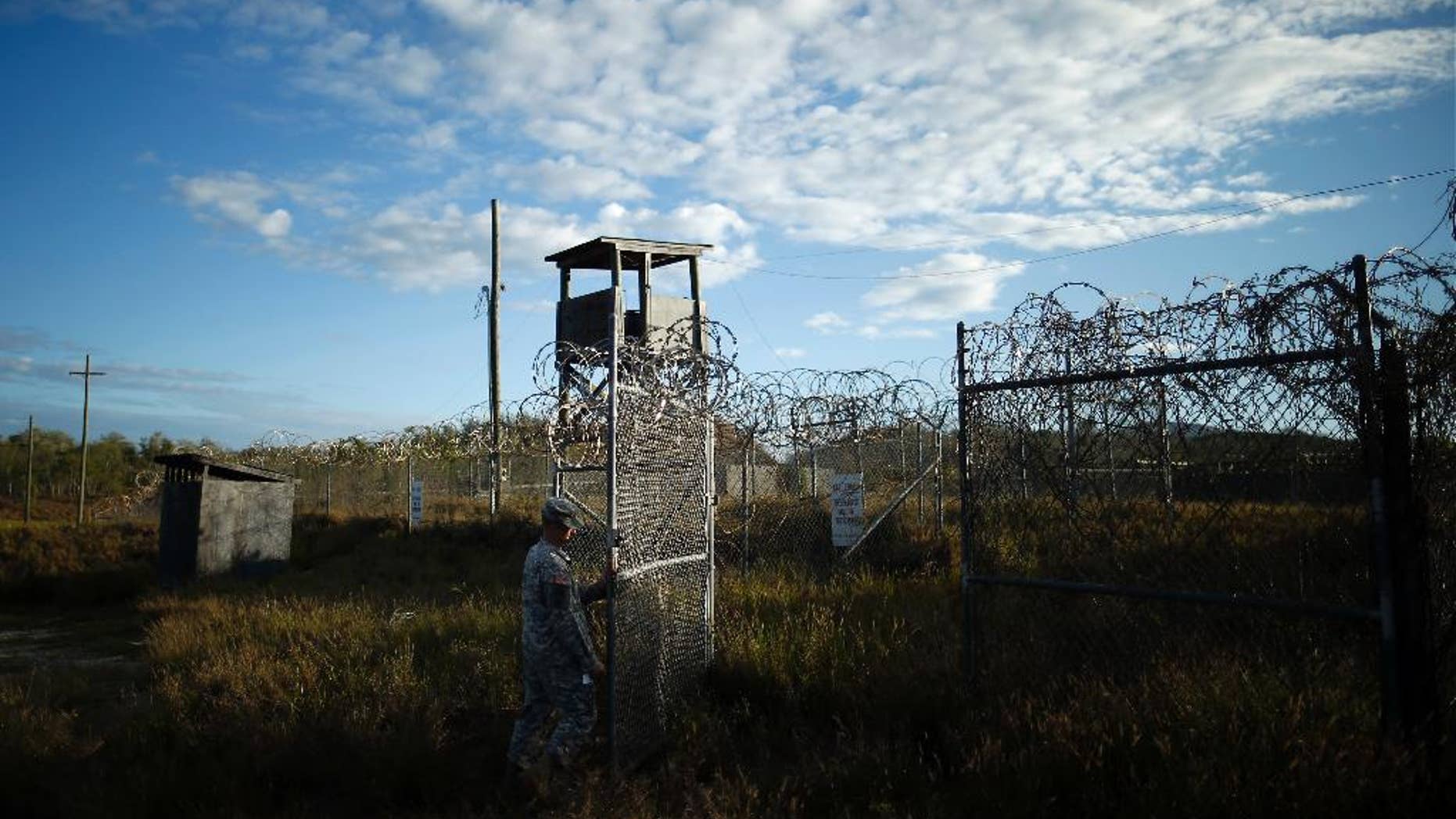 FILE - In this Nov. 13, 2013, file photo reviewed by the U.S. military, a soldier closes the gate at the now abandoned Camp X-Ray, which was used as the first detention facility for al-Qaida and Taliban militants who were captured after the Sept. 11 attacks at Guantanamo Bay Naval Base, Cuba. During six years behind bars at Guantanamo Bay, Abdul Rauf insisted he was a lowly Taliban foot soldier, even though he was really a corps commander. Rauf was released in 2007 and sent home to Afghanistan. He was working as the top recruiter in Afghanistan for Islamic State militants when a drone strike on Feb. 9, 2015, killed him along with seven others. (AP Photo/Charles Dharapak, File)