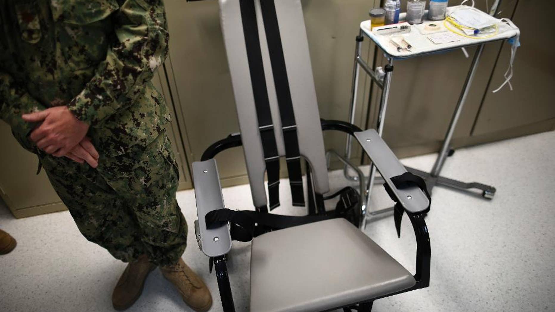 Nov. 20, 2013: A U.S. Navy nurse stands next to a chair with restraints, used for force-feeding, and a tray displaying nutritional shakes, a tube for feeding through the nose, and lubricants, including a jar of olive oil, during a tour of the detainee hospital at Guantanamo Bay Naval Base in Cuba.