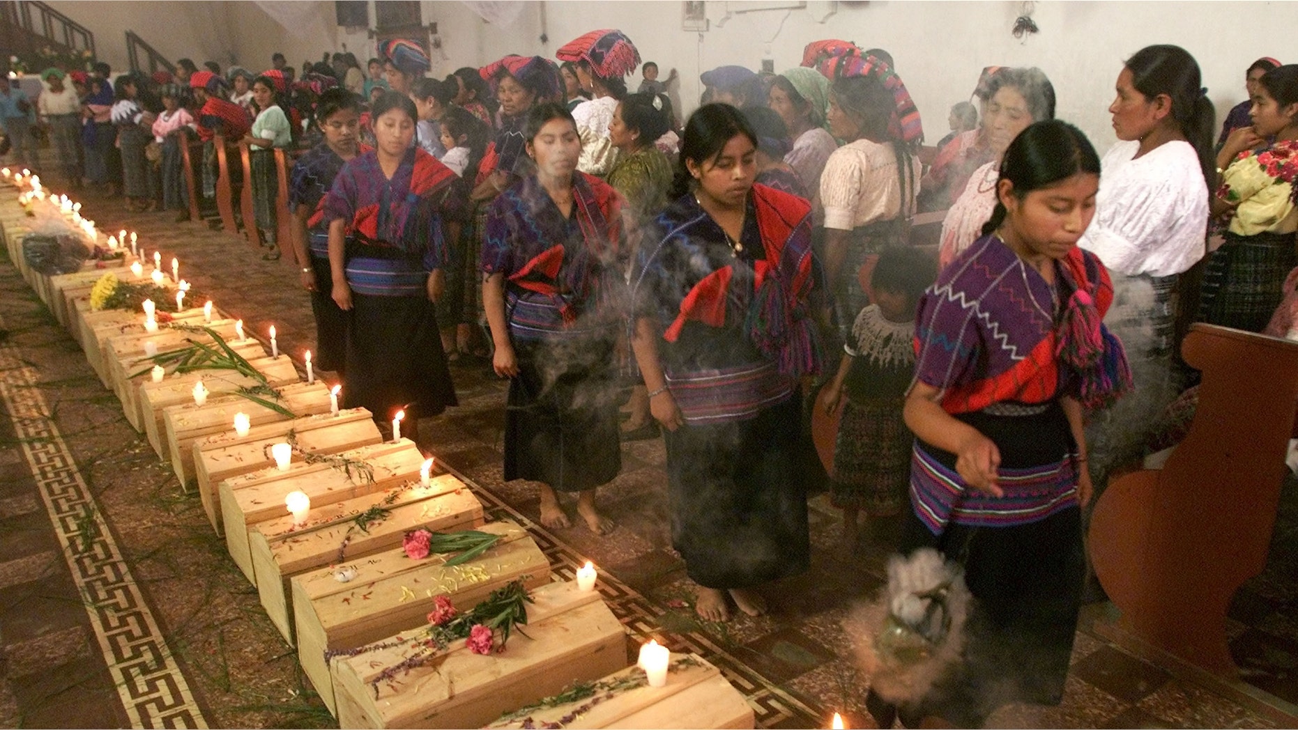 391523 03: Guatemalan Mayan Quiche Indian women dance and burn incense around 41 coffins of victims, found in a 1980''s clandestine cemetery, during mass July 5, 2001 in Zacualpa, Quiche, 150 miles northwest of Guatemala''s capital. According to the Guatemalan Anthropology Forensic Foundation, the cemetery is just one of 669 that has resulted from a 36-year civil war that left 200,000 missing people in the country. (Photo by Andrea Nieto/Getty Images)