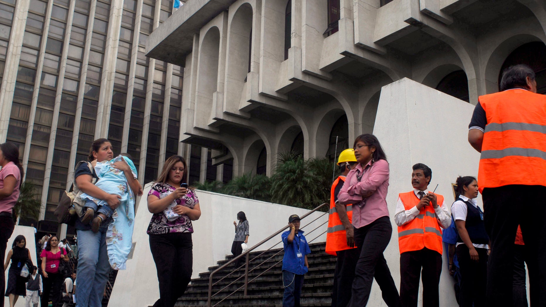 September 19: Residents stand outside the Supreme Court headquarters as volunteer workers organize an evacuation after earthquakes in Guatemala City.