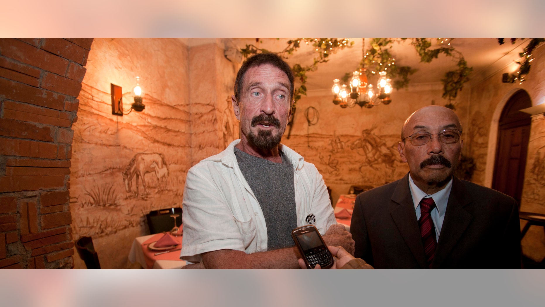Dec. 4, 2012: Software company founder John McAfee, left, accompanied by his lawyer Telesforo Guerra, right, answers questions during an interview at a local restaurant in Guatemala City.