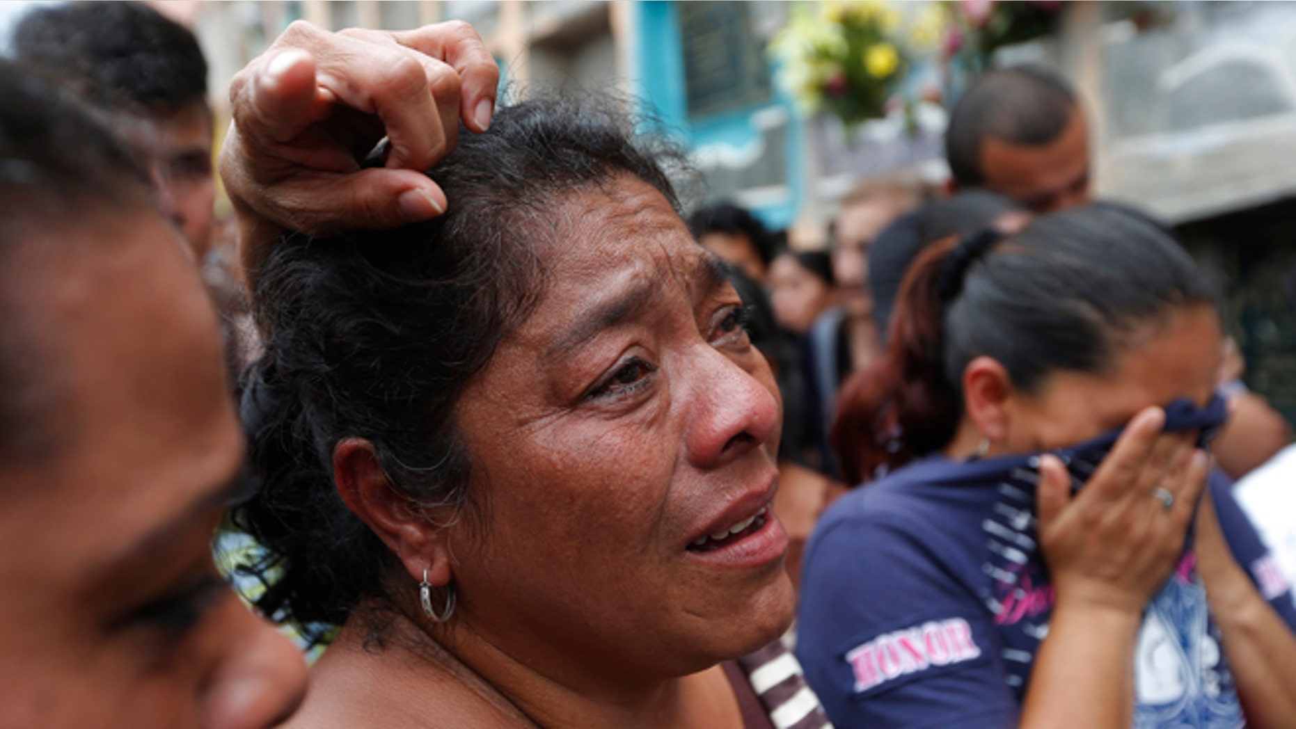 Relatives weep during the burial of Amilcar Estrada and his 10-year-old niece Maria Jose, who died in a mudslide, in the Santa Catarina Pinula cemetery on the outskirts of Guatemala City, Sunday, Oct. 4, 2015. Rescue workers recovered more bodies Saturday after a hillside collapsed on homes late Thursday, while more are feared still buried in the rubble. (AP Photo/Moises Castillo)