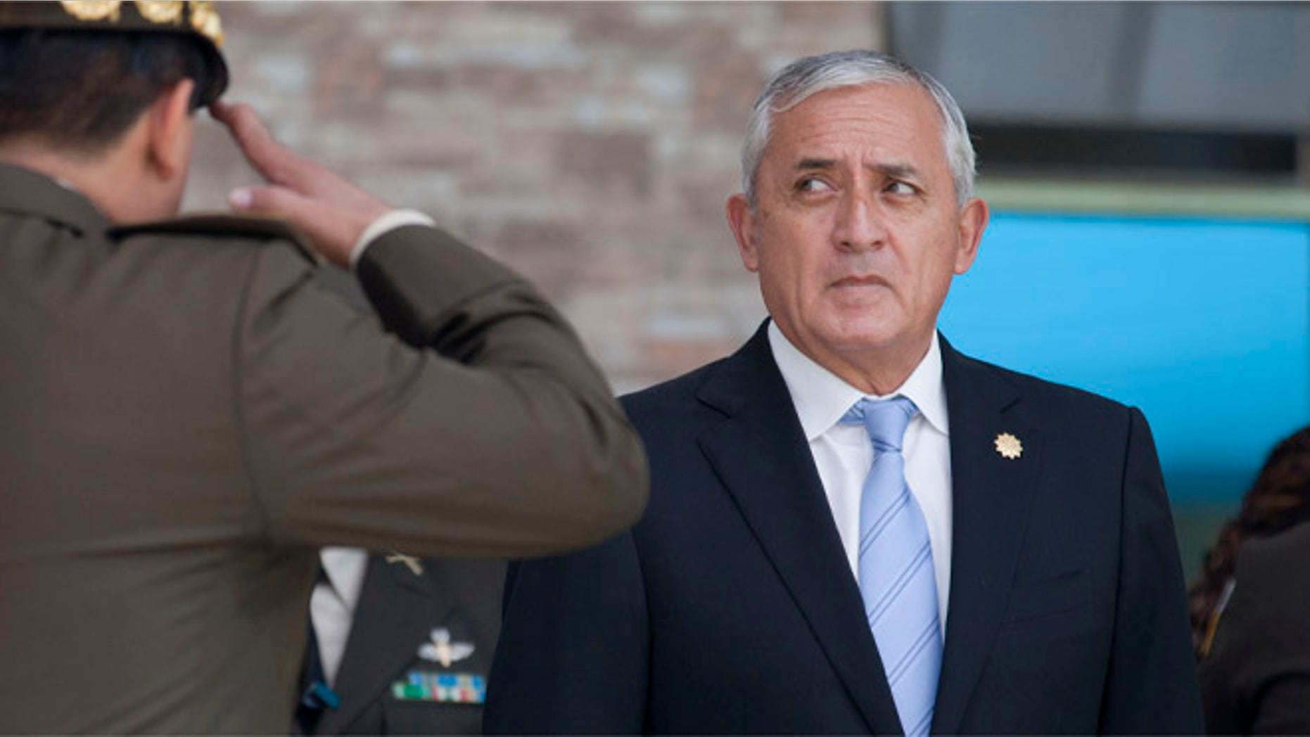 FILE - In this Aug. 14, 2015 file photo, a soldier salutes Guatemala's President Otto Perez Molina during a swearing-in ceremony for his newly-named defense minister, in Guatemala City. The attorney generalâs office of Guatemala issued a statement, urging the embattled leader to step down. The office said in a statement posted on its website late Wednesday, Aug. 26, 2015, that Perez Molina should âsubmit his resignation, to prevent ungovernability.â (AP Photo/Moises Castillo, File)