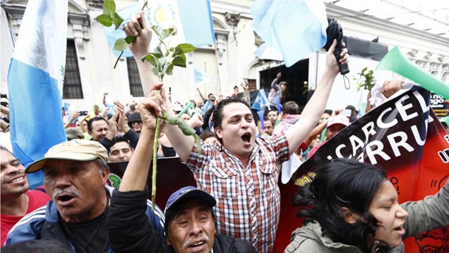 Demonstrators react in jubilation in front of the Guatemalan Congress building as they hear the news that Congress has voted to withdraw President Otto Perez Molina's immunity from prosecution, in Guatemala City, Tuesday, Sep. 1, 2015. Perez Molina's government has been beset by a series of corruption cases, but until now he has been immune to prosecution as president. (AP Photo Moises Castillo)