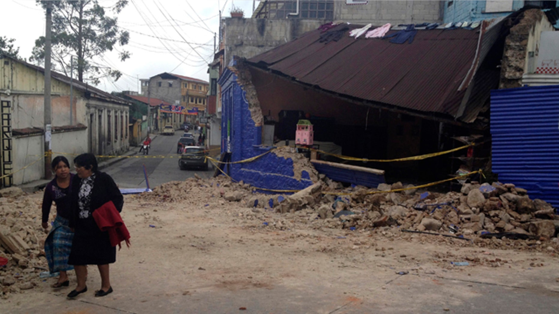 Nov. 7, 2012: Two women walk past a building damaged after a magnitude 7.4 earthquake struck in San Marcos, Guatemala.
