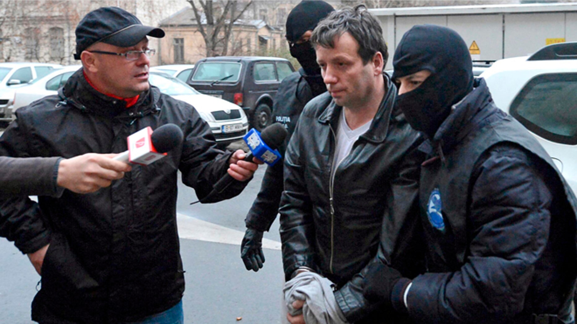 Jan. 22, 2014: Marcel Lazar Lehel, 40, is escorted by masked policemen in Bucharest, after being arrested in Arad, 337 miles west of Bucharest. Lehel is allegedly the hacker using the nicknames "Guccifer" and "The Small Fume" and is suspected to have broken into several e-mail accounts of various politicians and celebrities and the head of Romania's Intelligence Service George Maior.