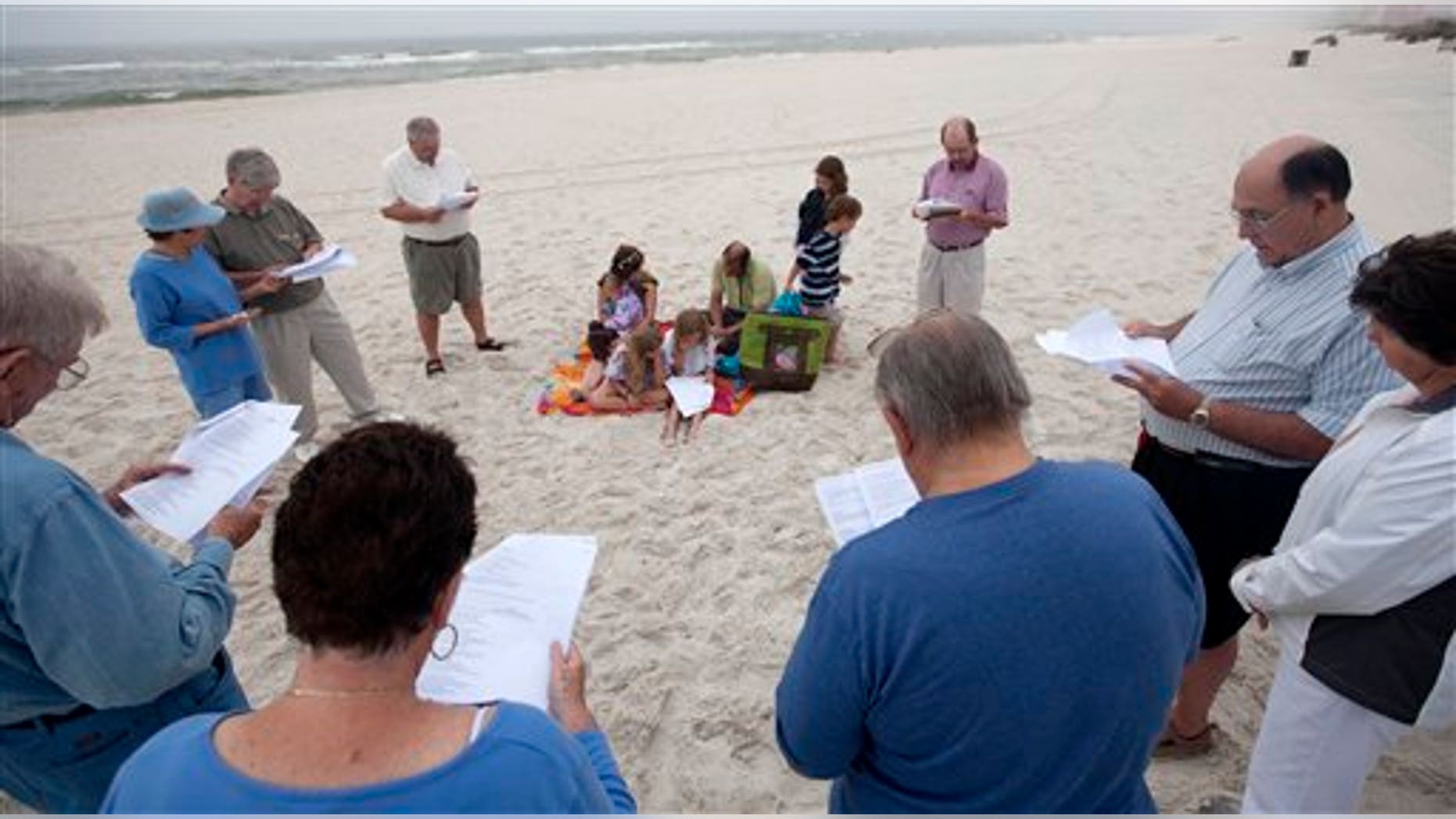 April 20: People gather in prayer at dawn during a prayer vigil for those who suffered following the Deepwater Horizon incident in Orange Beach, Ala.
