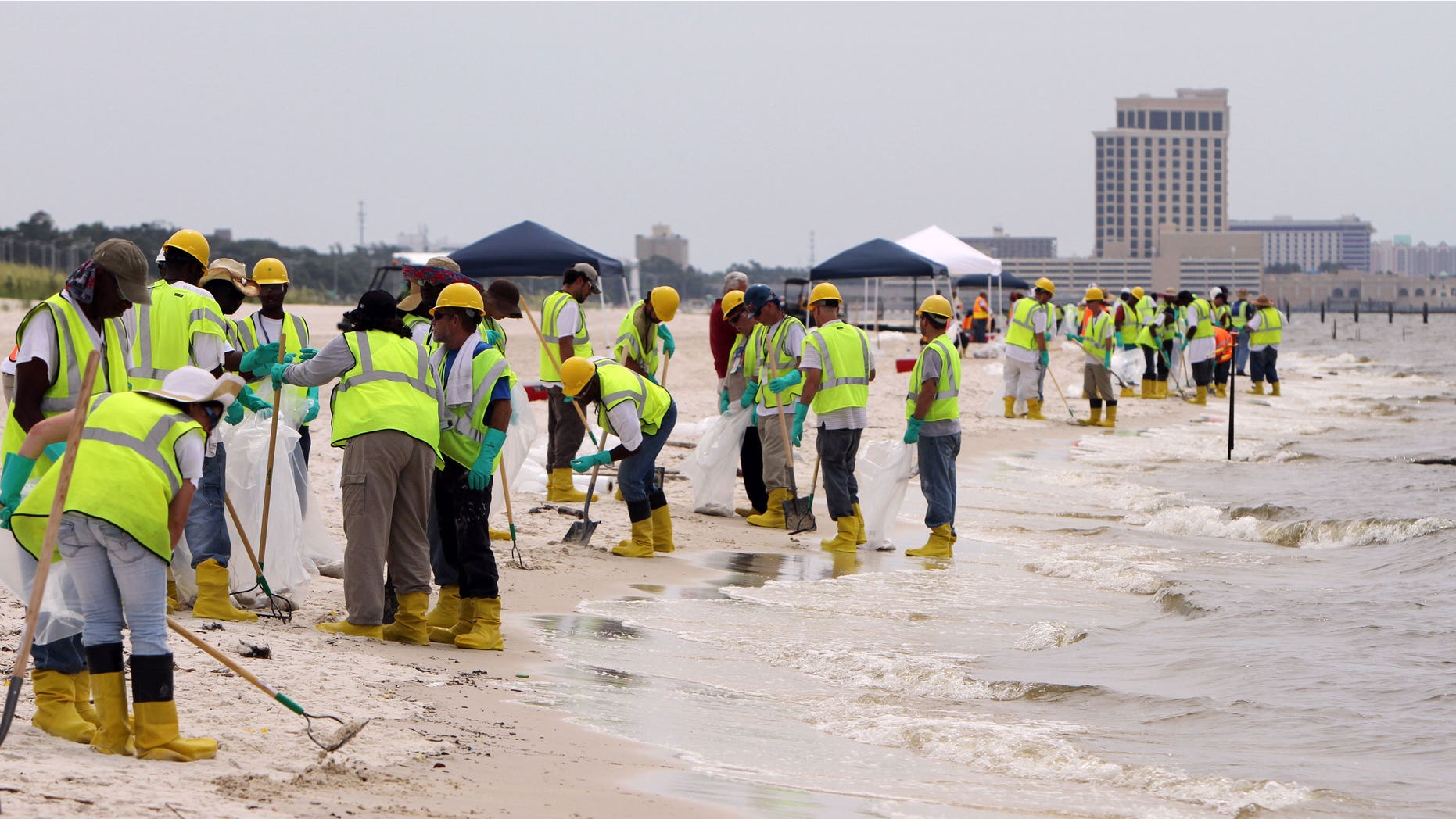 June 28: About three hundred BP contract workers tend to the beaches in Biloxi, Miss., to remove tar balls that had washed ashore over the weekend. (AP)
