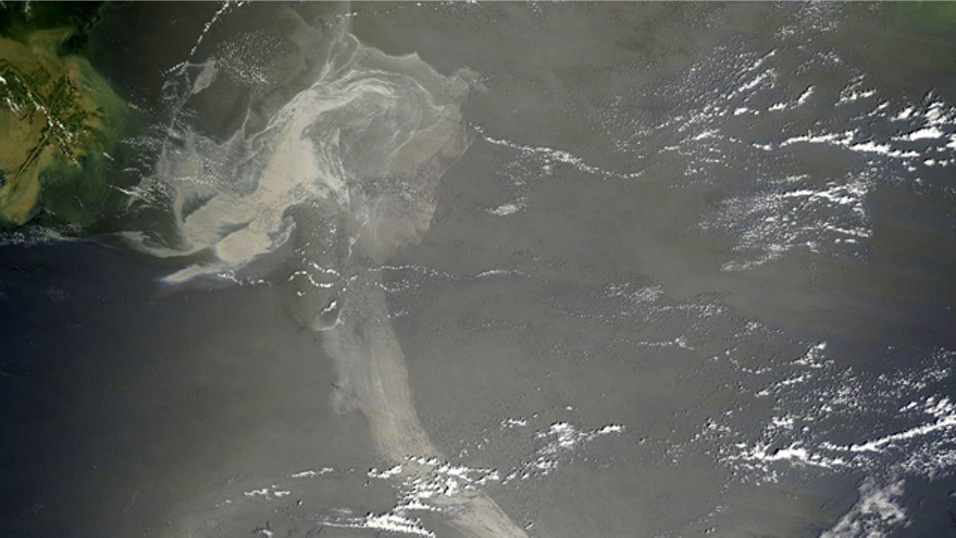 A May 17, 2010 satellite image provided by NASA shows a large patch of oil visible near the site of the Deepwater oil spill, and a long ribbon of oil stretched far to the southeast. NOAA said Wednesday that a small portion of the slick had entered the so-called loop current, a stream of fast moving water that circulates around the Gulf before bending around Florida and up the Atlantic coast.
