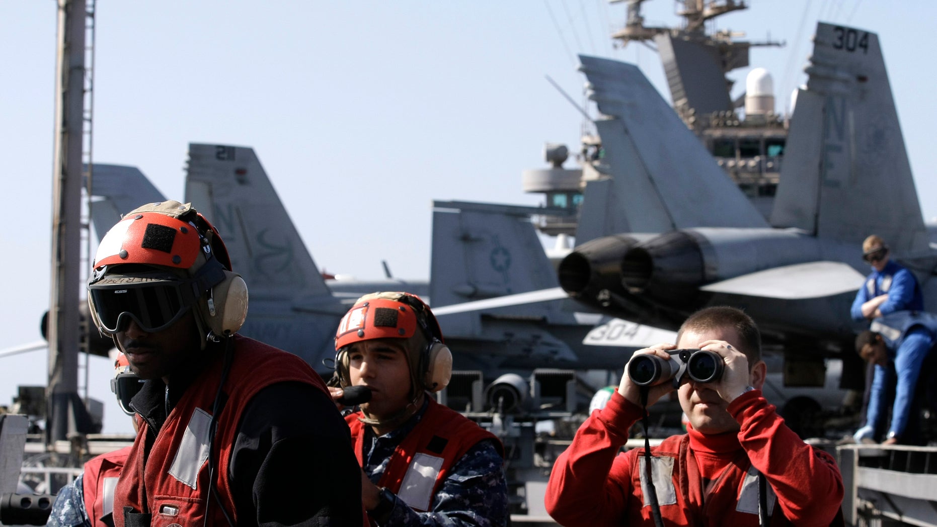 Feb. 14, 2012: Crew look out over the Arabian sea from the flight deck of the Nimitz-class aircraft carrier USS Abraham Lincoln (CVN 72) in the Strait of Hurmuz.